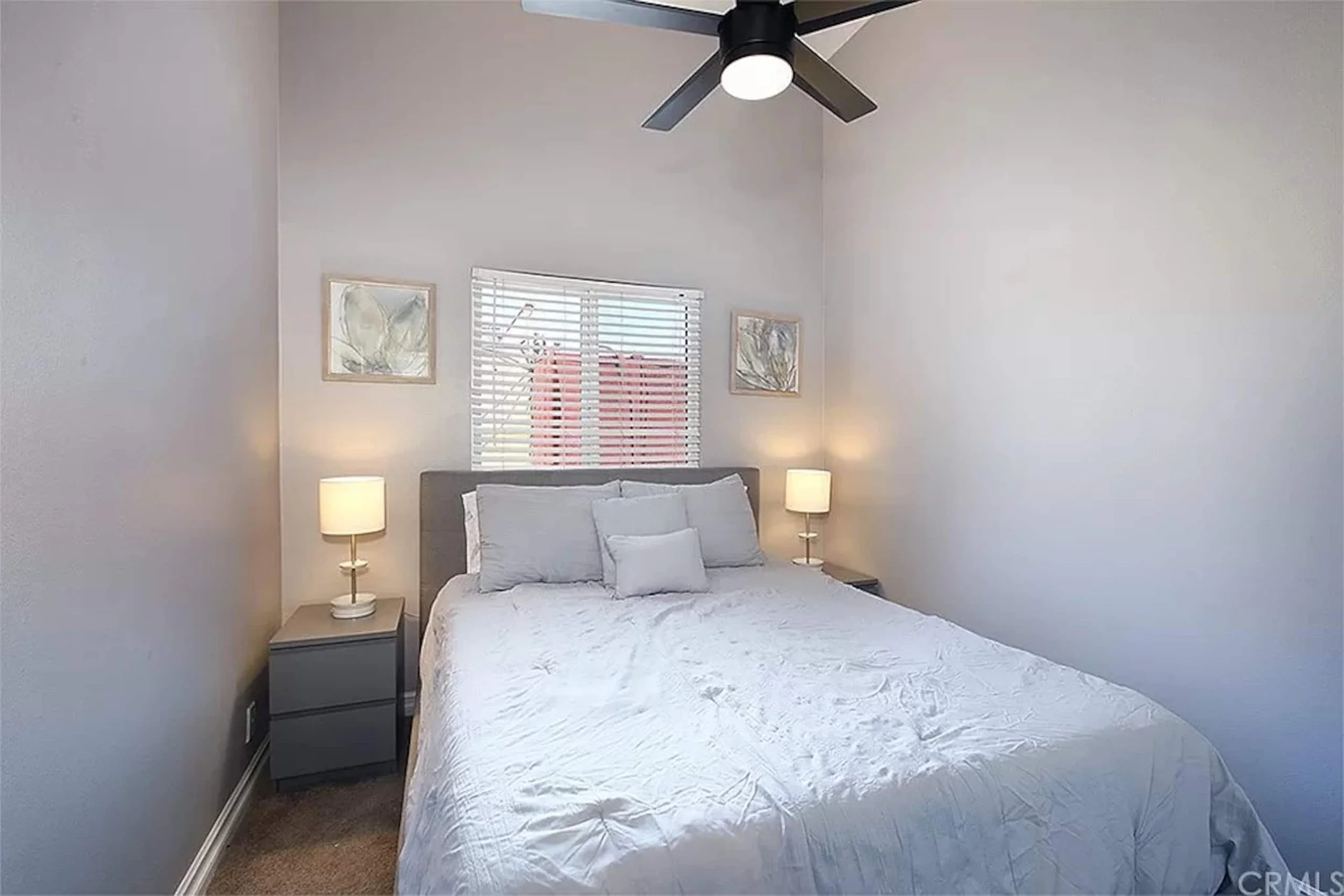 Guest bedroom with a queen bed framed by matching nightstands and lamps
