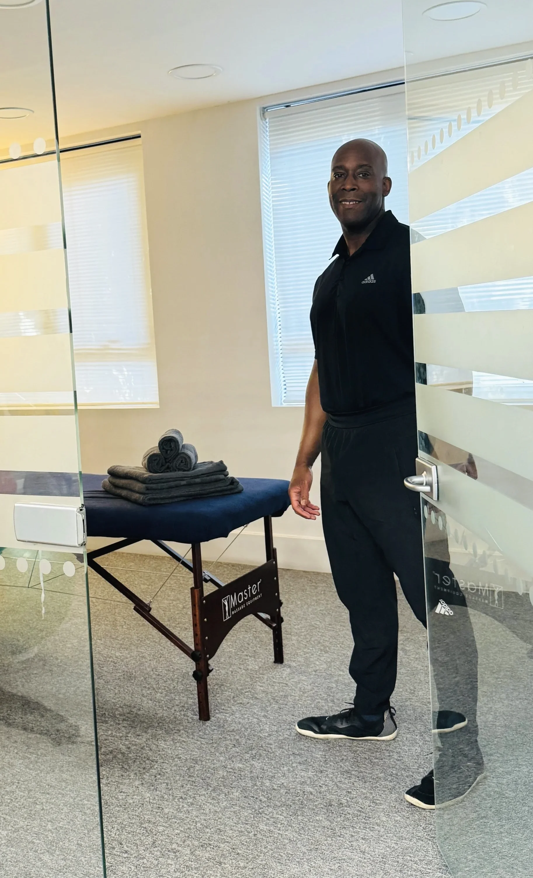 Sports massage therapist Nathan welcoming clients into the clinical treatment room at My Therapy Method. Features a professional massage table for sports massage and injury rehabilitation.