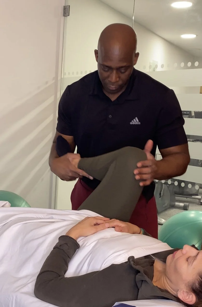 Professional sports massage therapist Nathan performing passive hip mobility and joint mobilisation on a female patient. This clinical injury rehabilitation treatment at My Therapy Method aims to relieve hip tightness, sciatic and lower back pain.