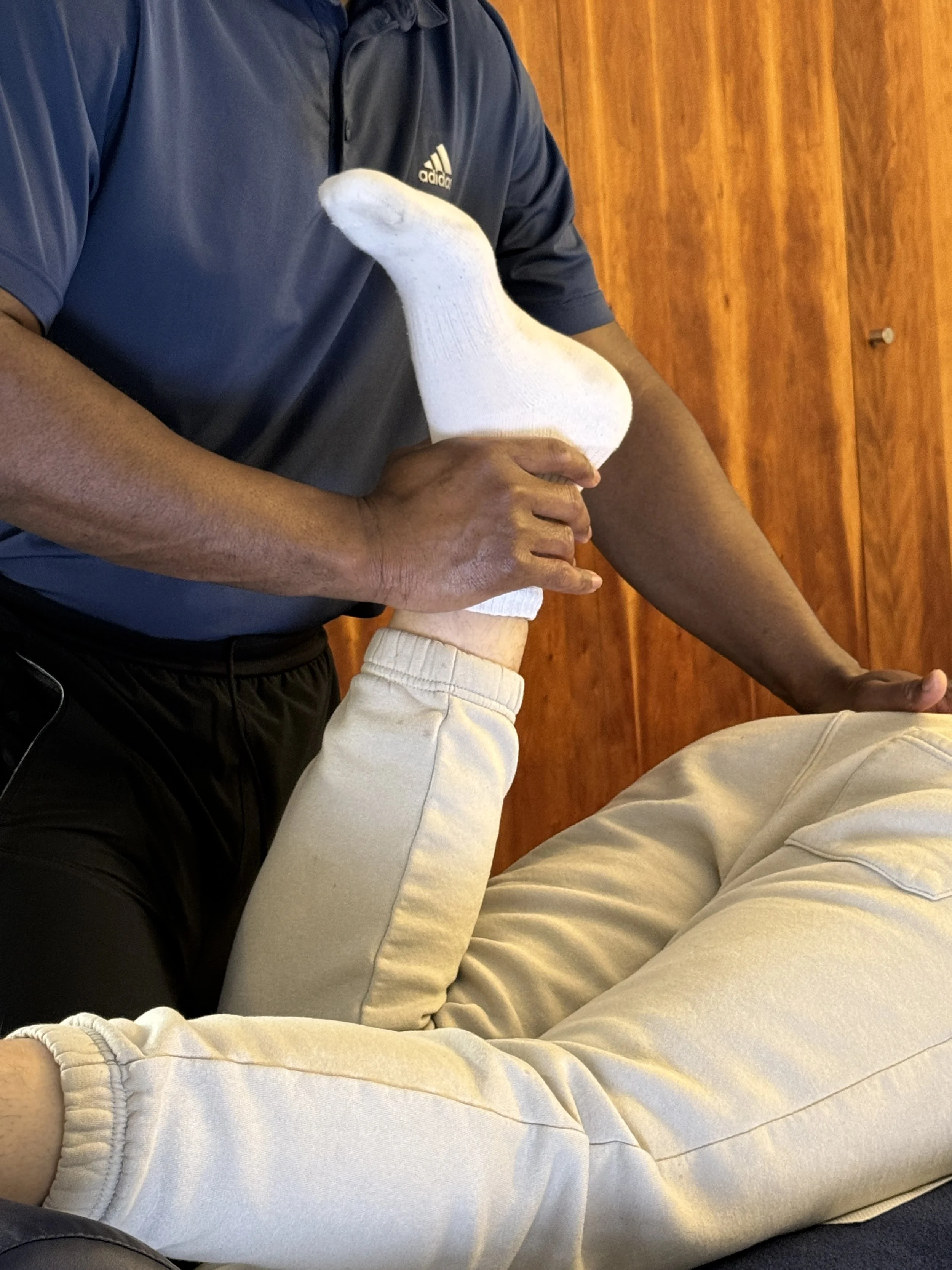 Therapist performing a targeted passive quad and hip flexor stretch during a Performance Sports Massage session to relieve deep-seated muscle tension and improve athletic mobility.