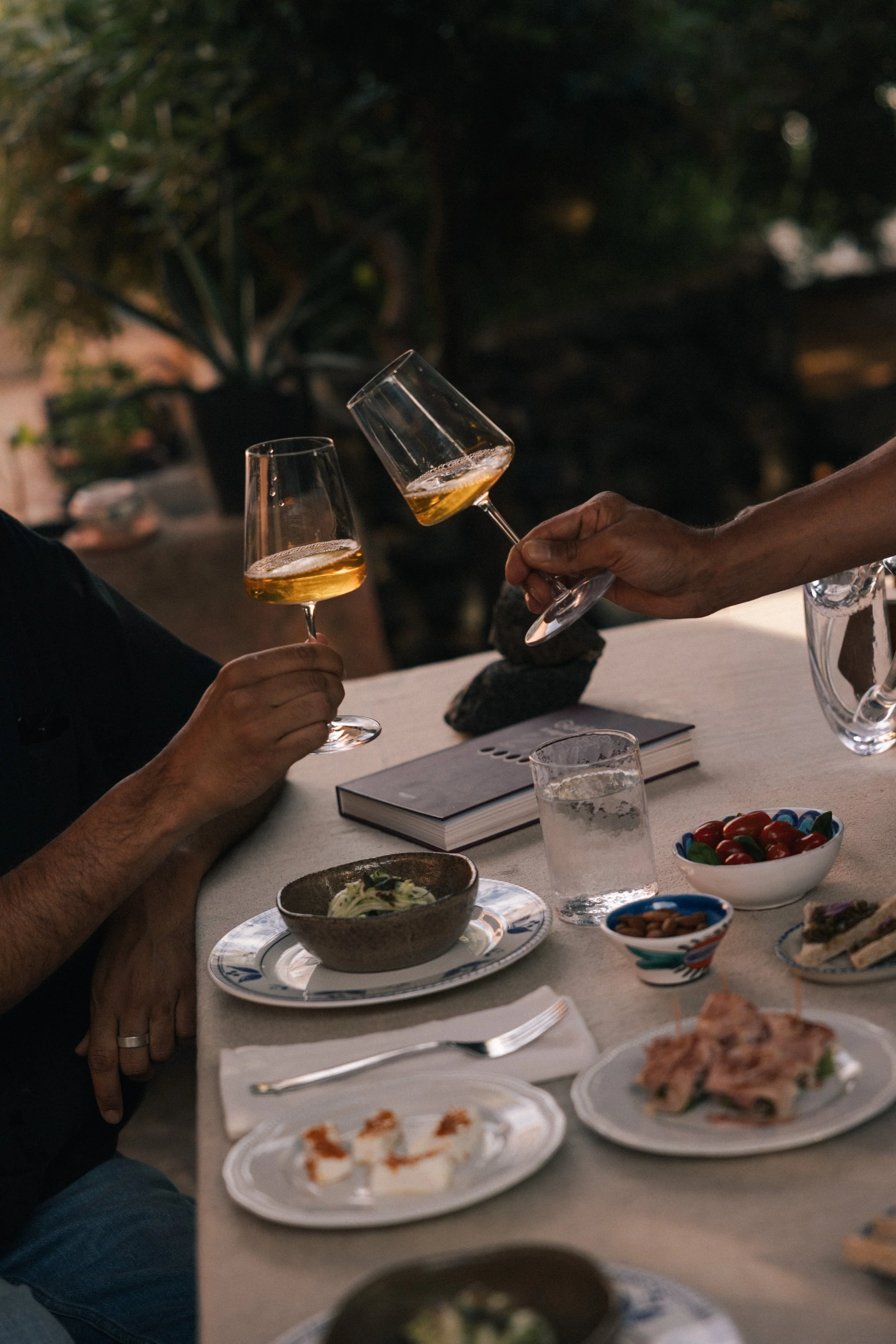 hands raising glasses of rosé wine Anforaje UMA for a toast 