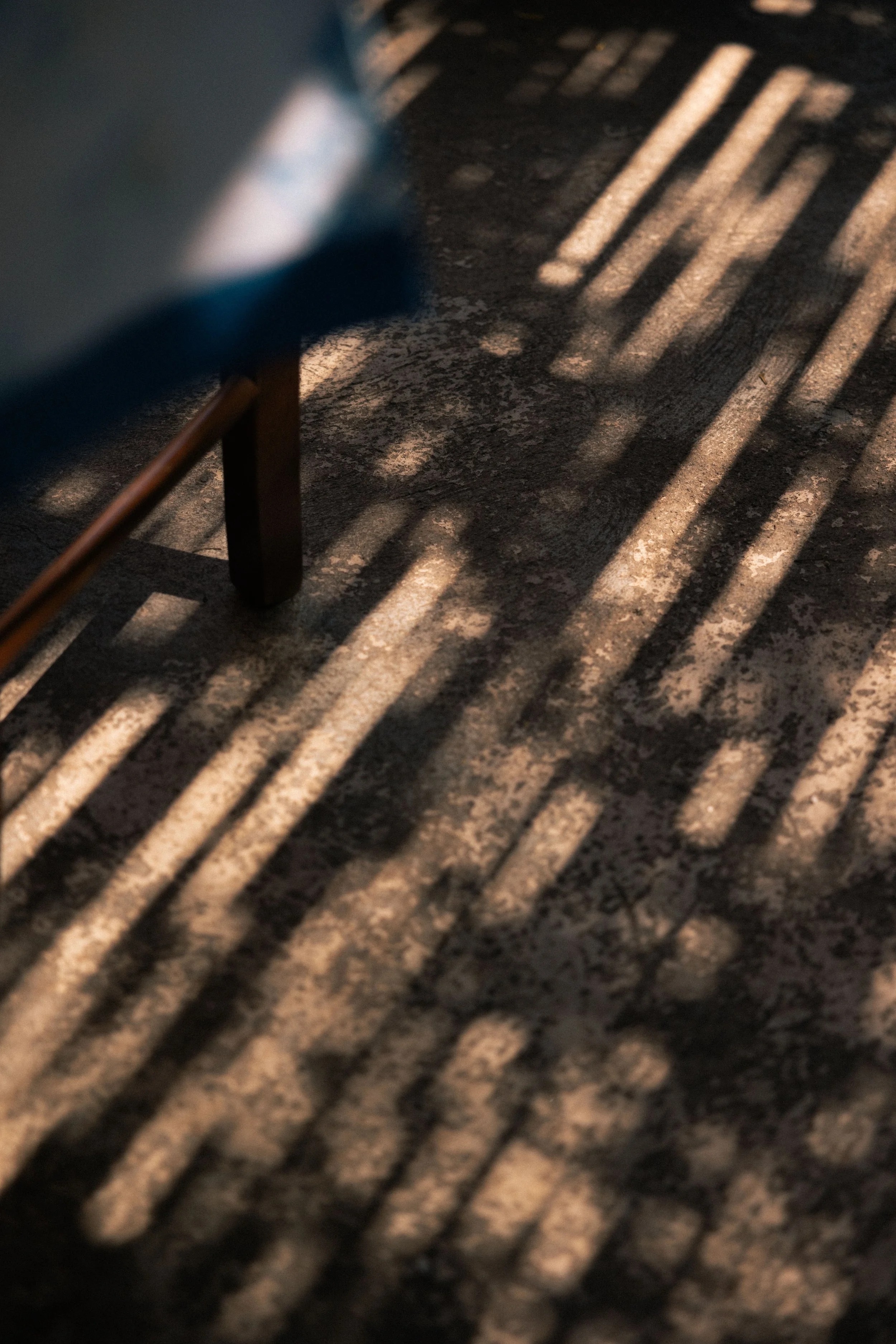 Shadowy pattern of stripes created by the island sunlight shining through a bamboo fence 