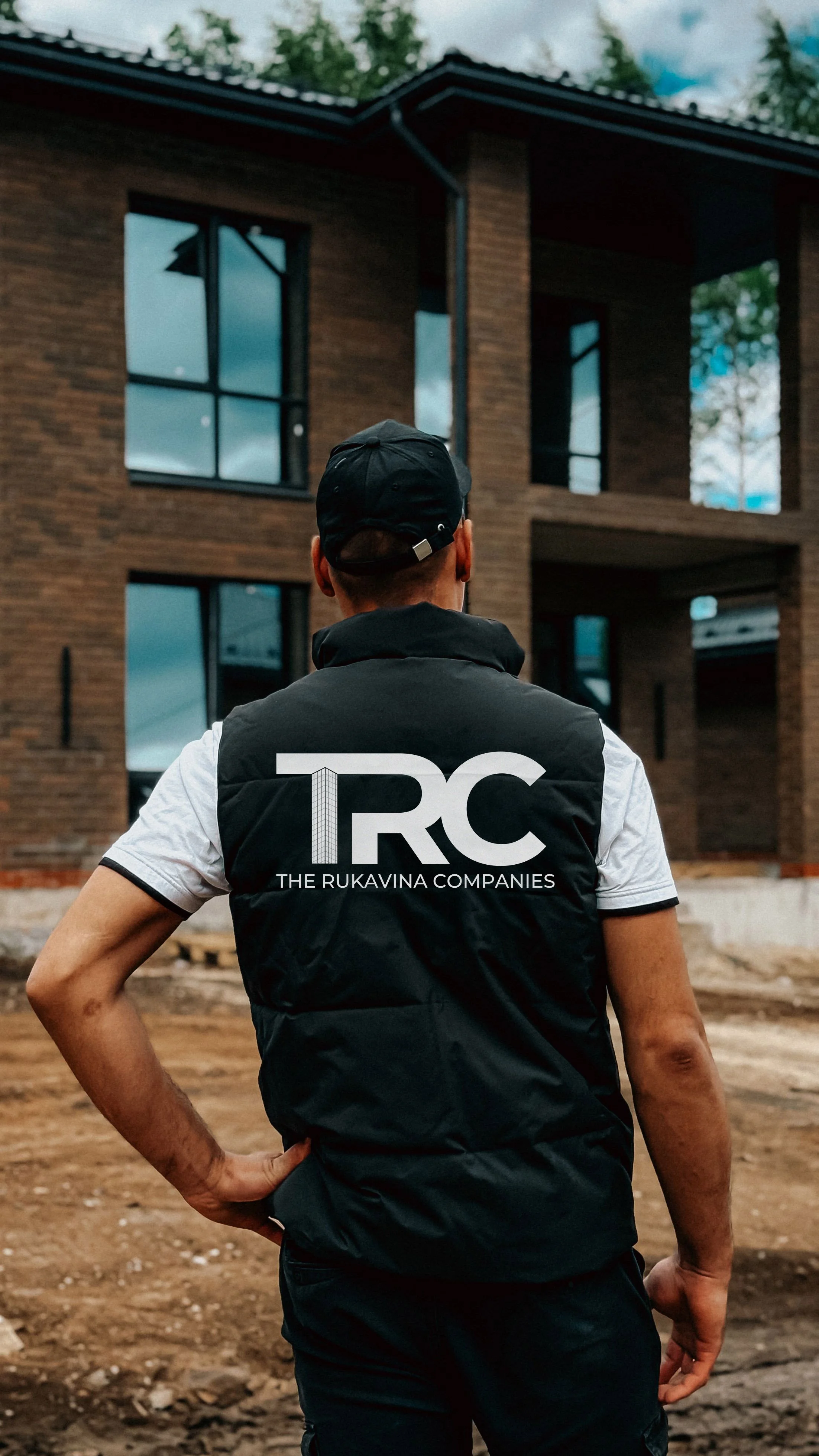 The Rukavina Companies team member in branded vest reviewing residential construction progress on jobsite