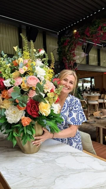 Joanna Puciata smiling, holding a large bouquet of flowers