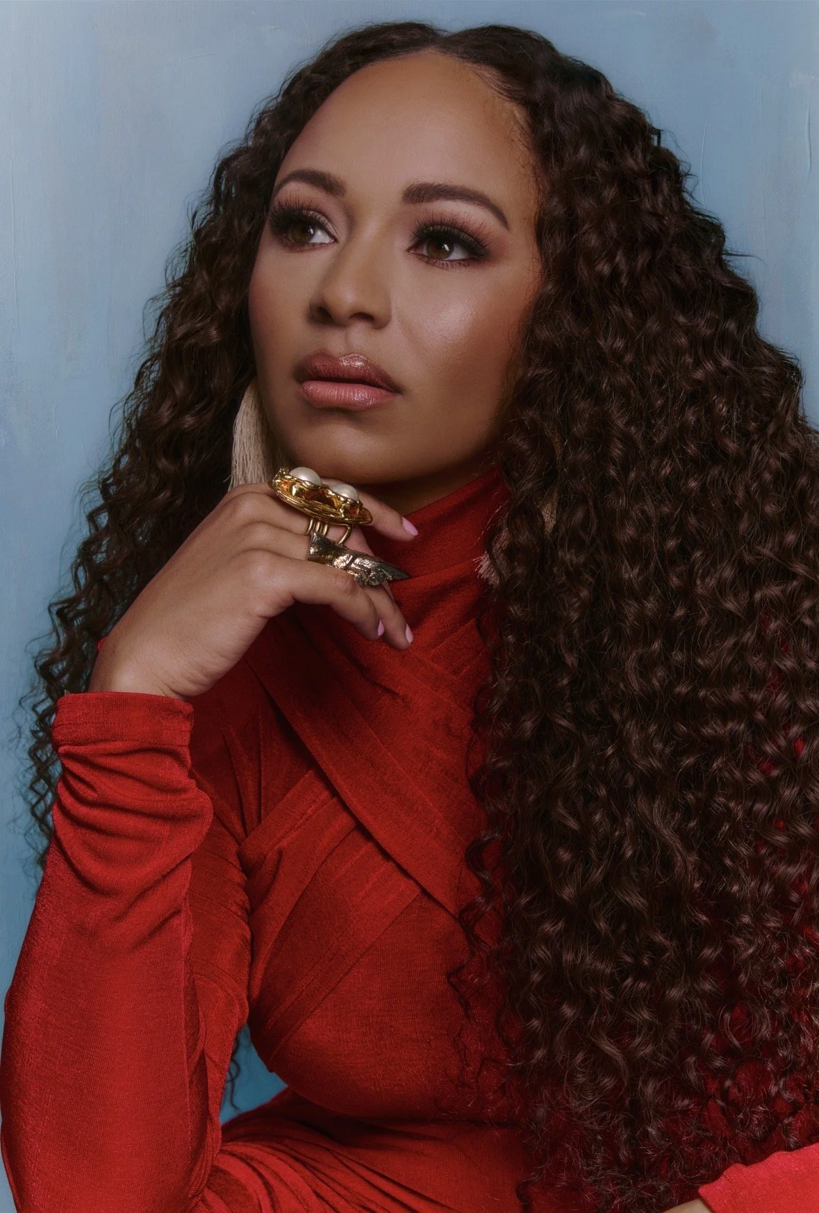 Woman with long dark hair wearing a burgundy dress.