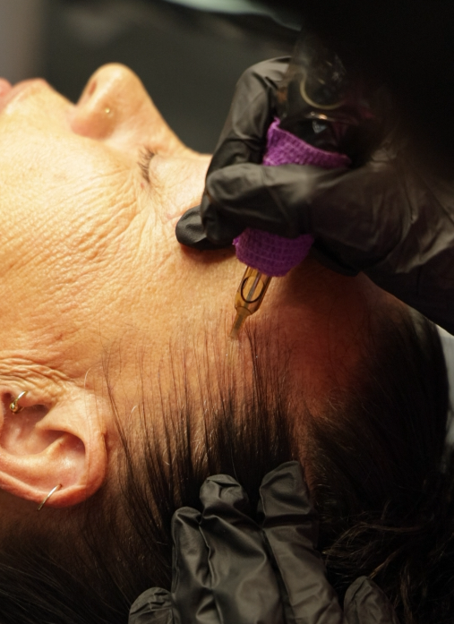 A person receiving a cosmetic injection in their neck area, administered by a professional wearing black gloves.