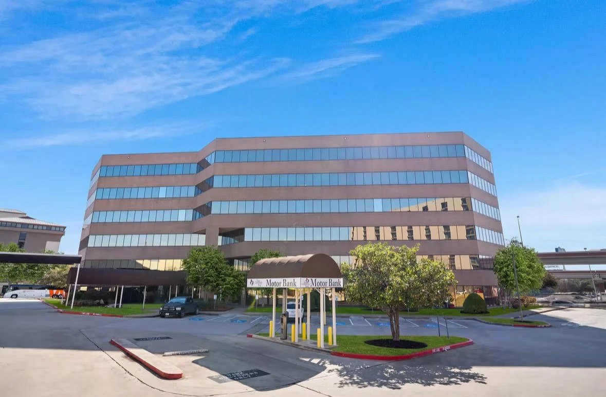 outside of Reset remedy's office building with reflective glass windows and a parking lot in front.