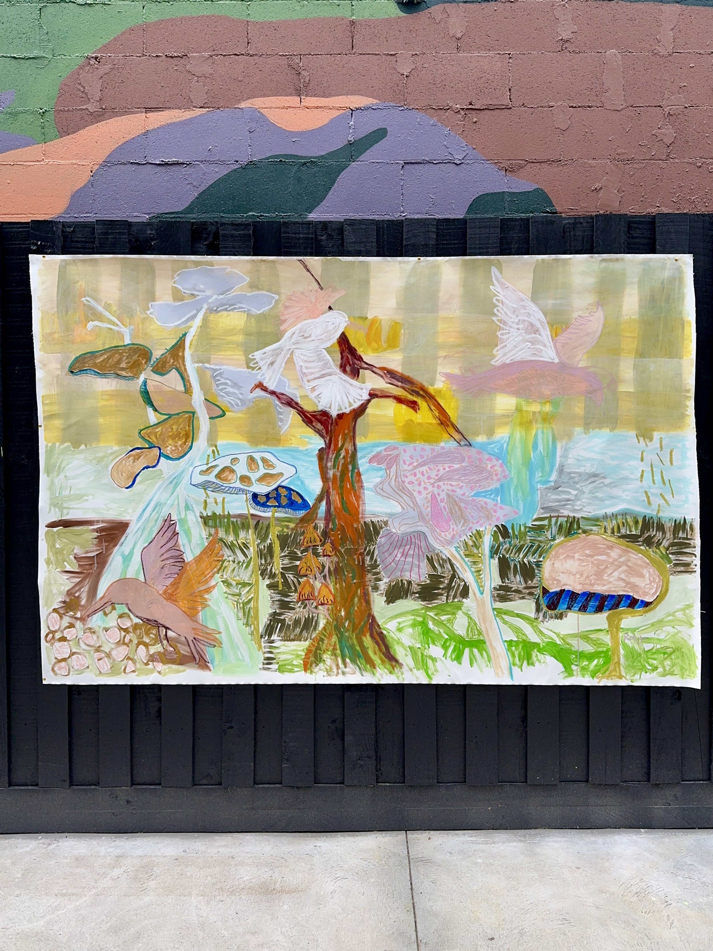 Colorful mural painting on a brick wall, featuring abstract shapes and a painting of birds and plants.
