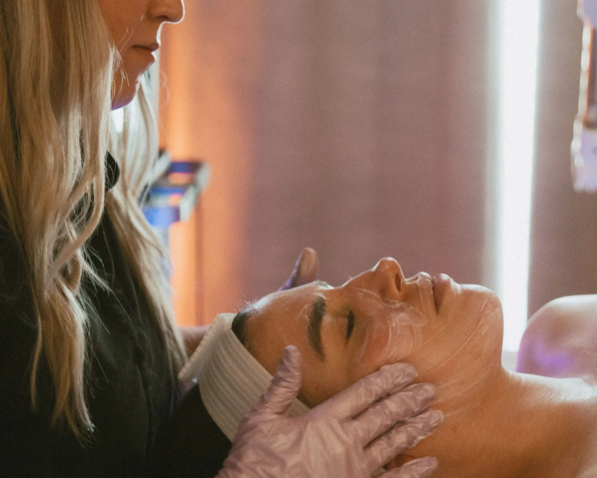 An esthetician performing a facial treatment on their client.