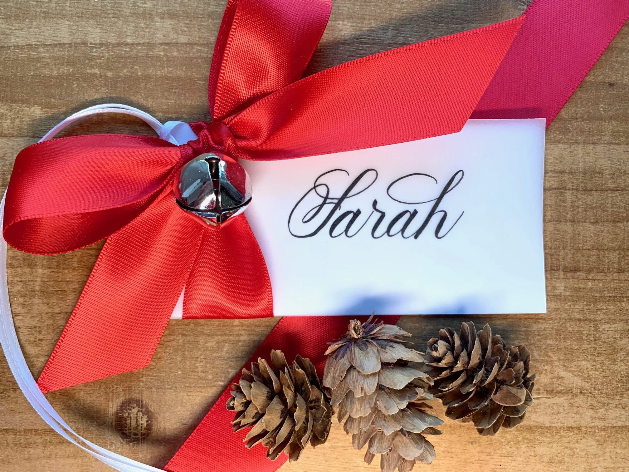 Christmas calligraphy personalized gift tag with jingle bell and red satin bow