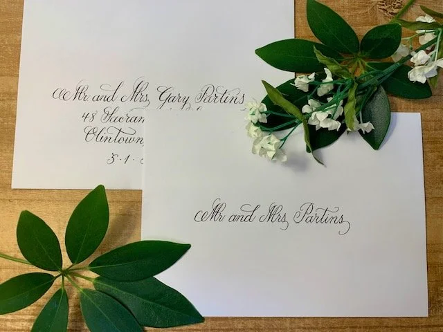 Formal calligraphy on inner and outer white wedding envelopes with black ink.