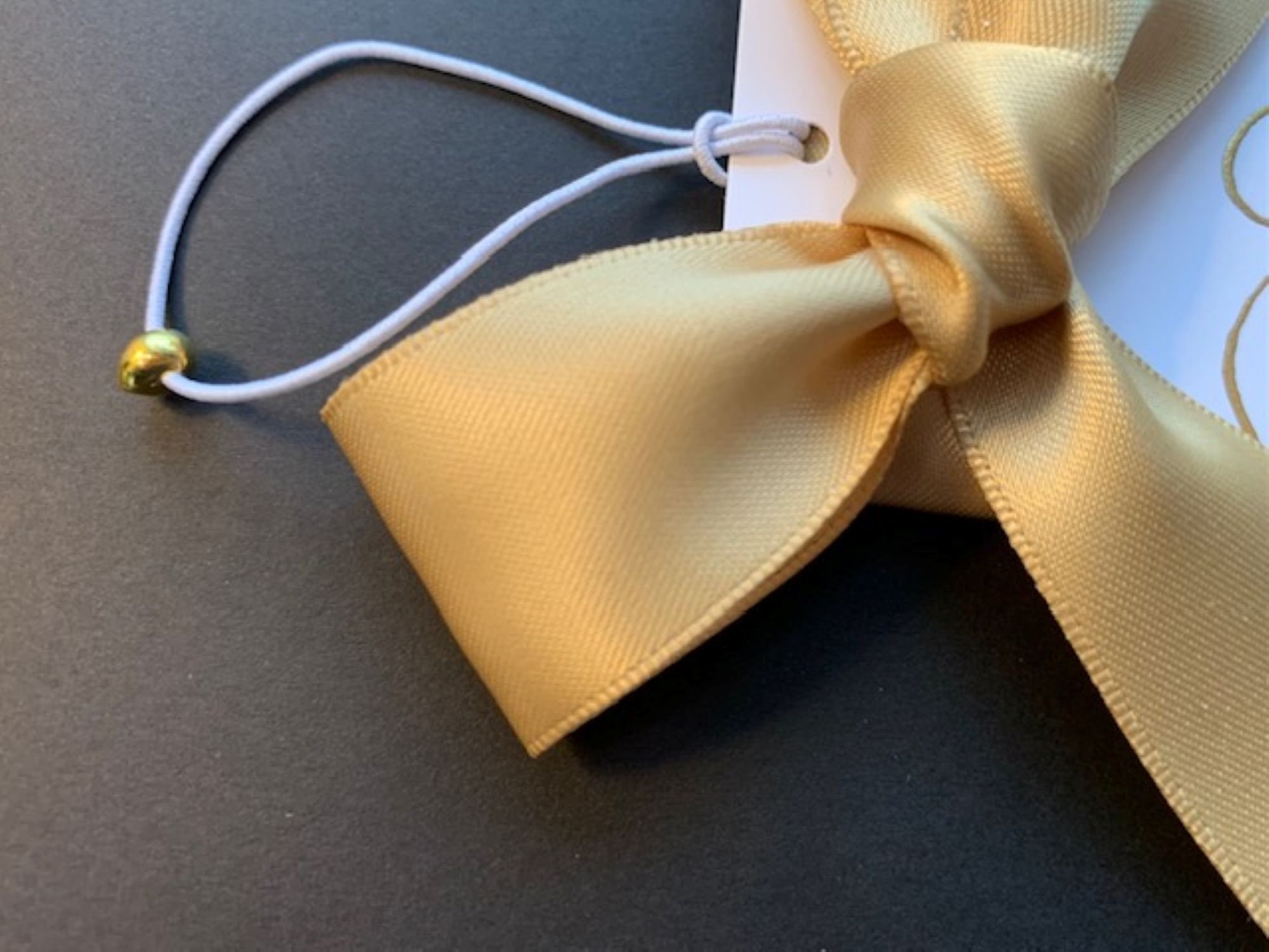 Gold satin bow wine bottle gift tag with elastic and gold bead to slip over bottle.
