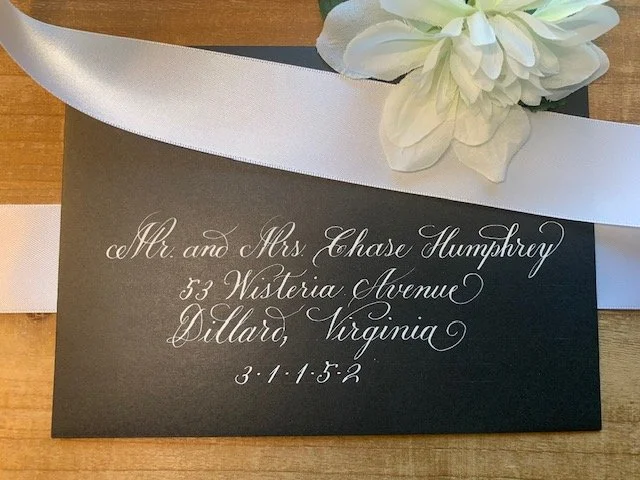 Black wedding envelope with elegant white ink calligraphy handwritten address.