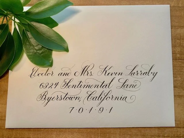 Cream colored wedding envelope with elegant black ink calligraphy handwritten address.
