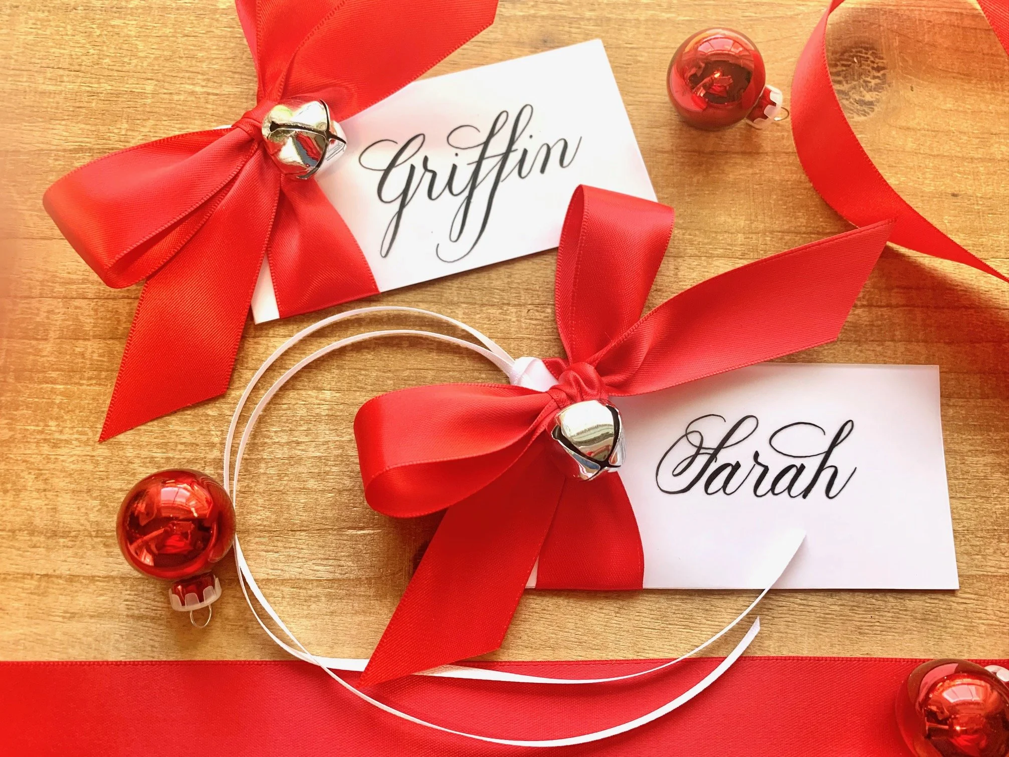Christmas calligraphy personalized place card and gift tag with jingle bell and red satin bow
