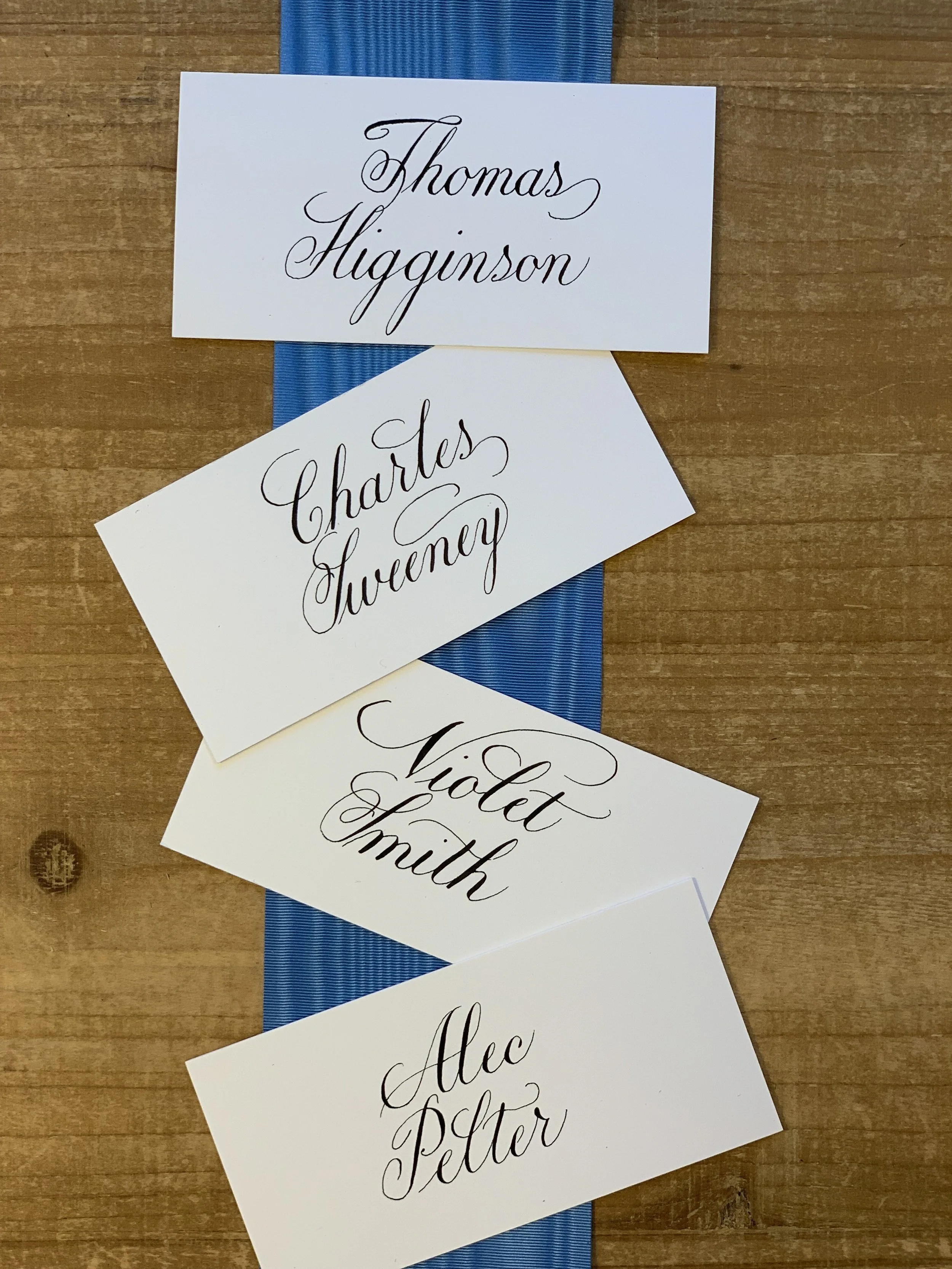 Calligraphy place cards personalized with first or full names in black ink.