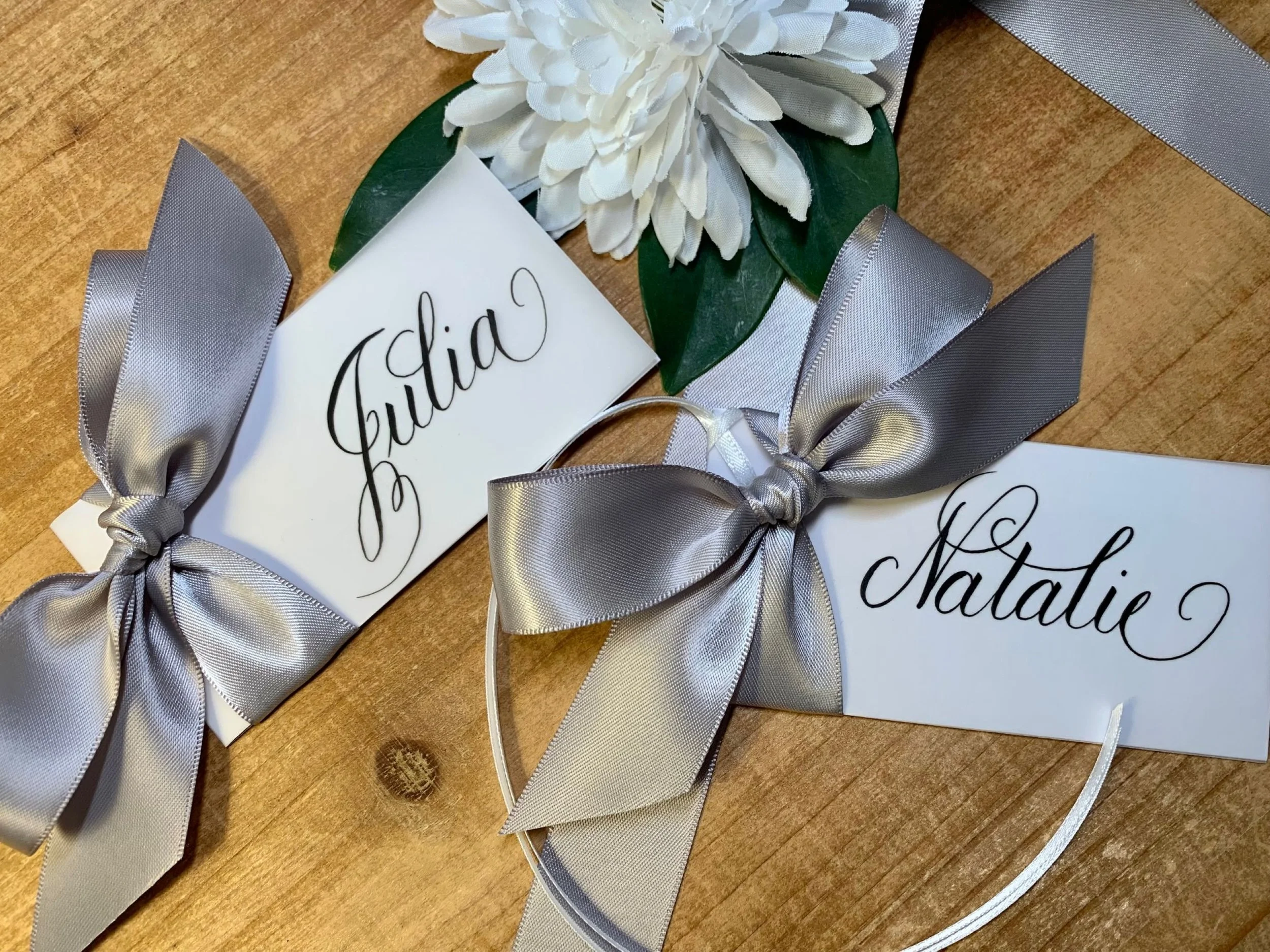 Silver ribbon and bow on calligraphy place card and gift tag for wedding
