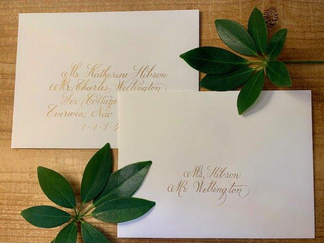 Formal calligraphy on inner and outer cream colored wedding envelopes with gold ink.