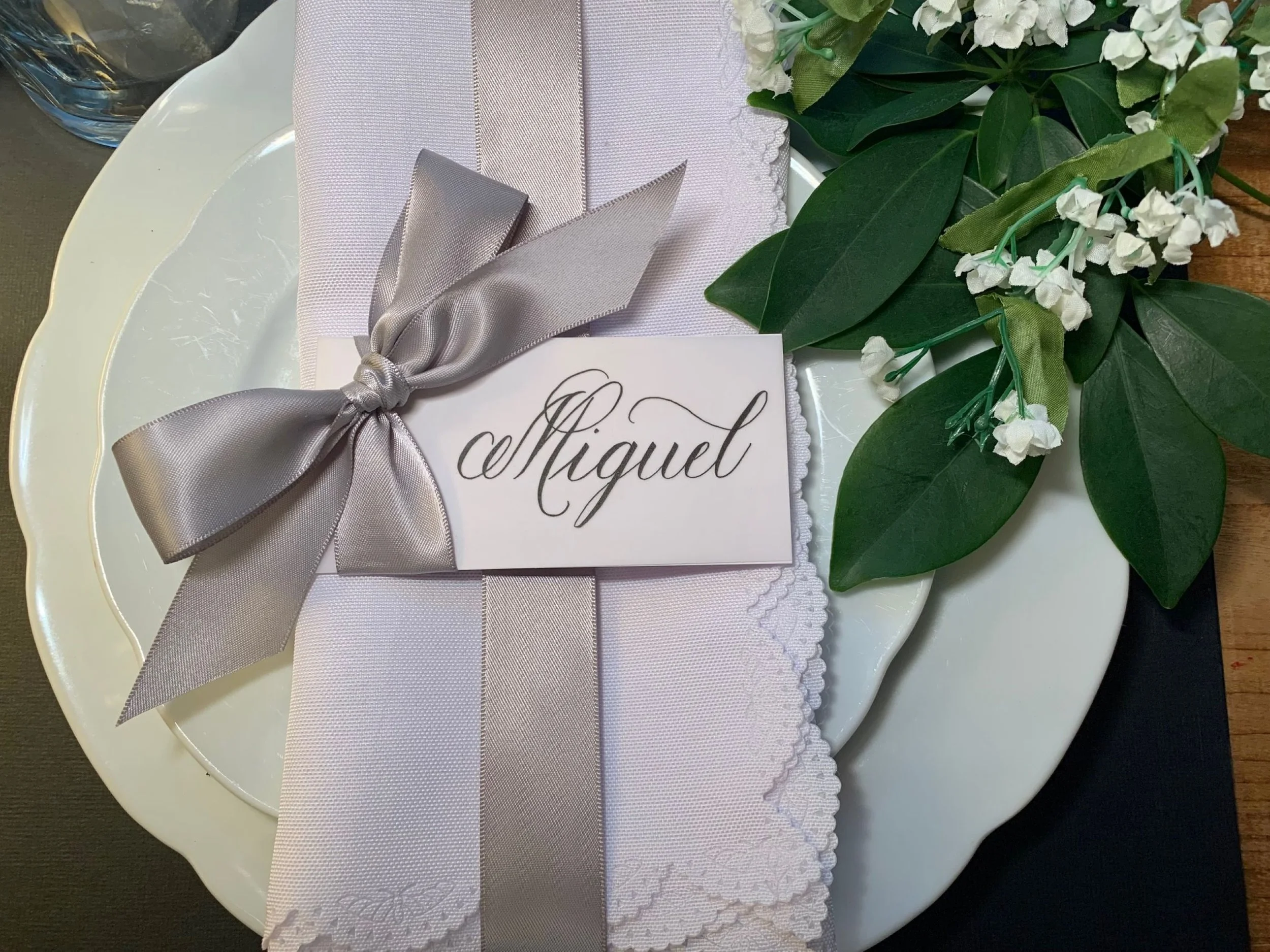 Silver ribbon embellished place card with first name written in calligraphy