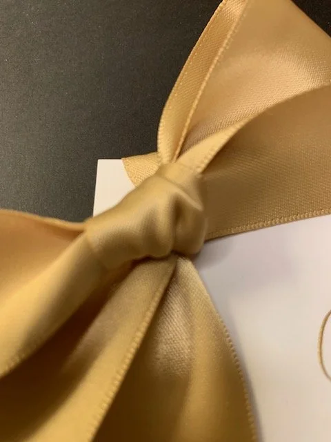 Close up of gold satin ribbon place card for wedding or special event.