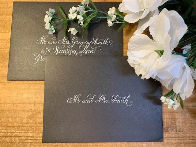 Formal calligraphy on inner and outer black wedding envelopes with white ink..
