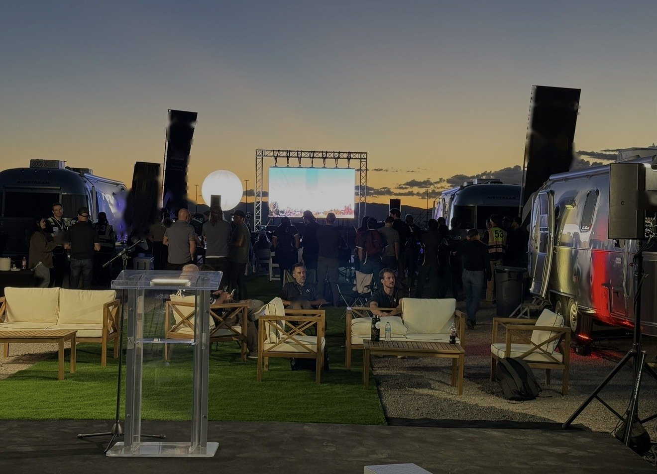 Brand activation: Airstream lounge with outdoor screen and lounge seating at sunset
