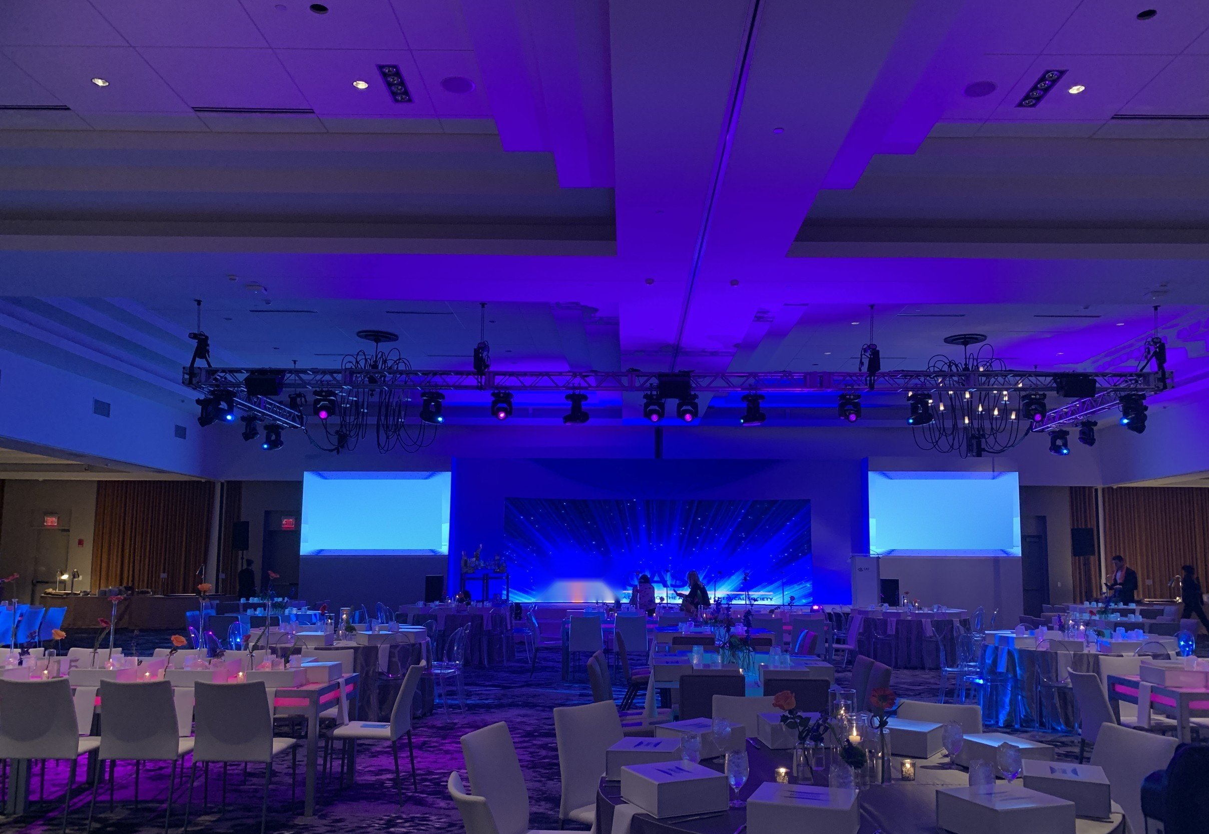 Ballroom gala dinner: LED stage backdrop, side screens and a flown truss with moving lights