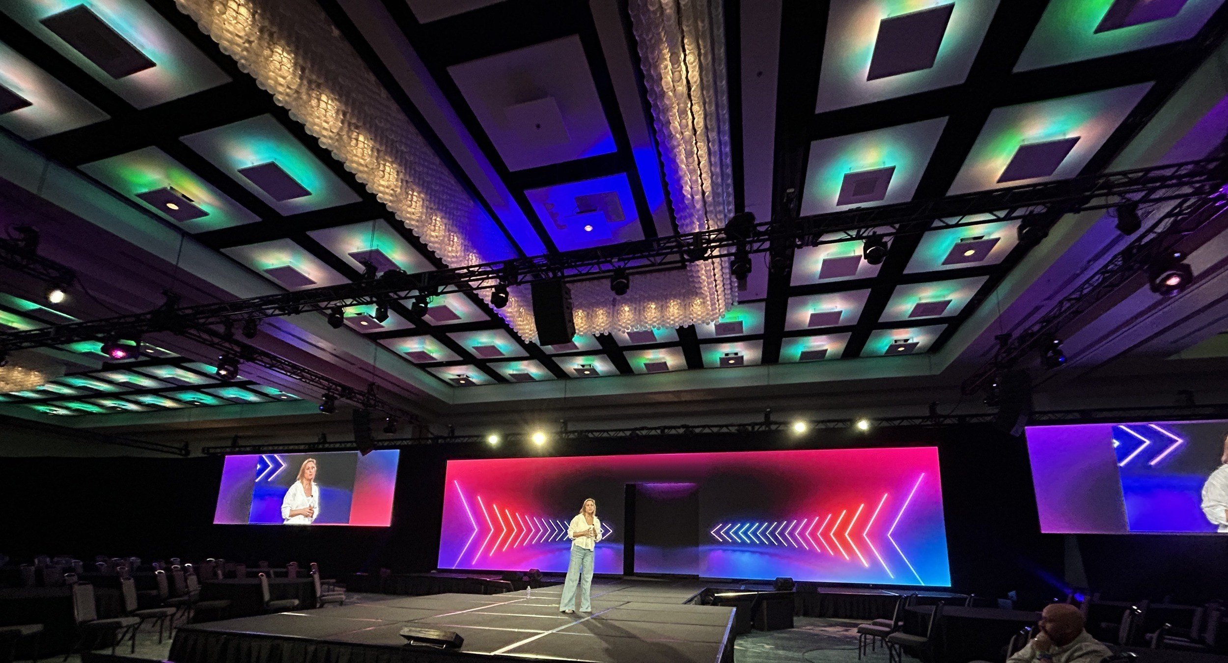 Ballroom keynote: pixel lit coffered ceiling, wide LED backdrop, IMAG screens and a thrust stage