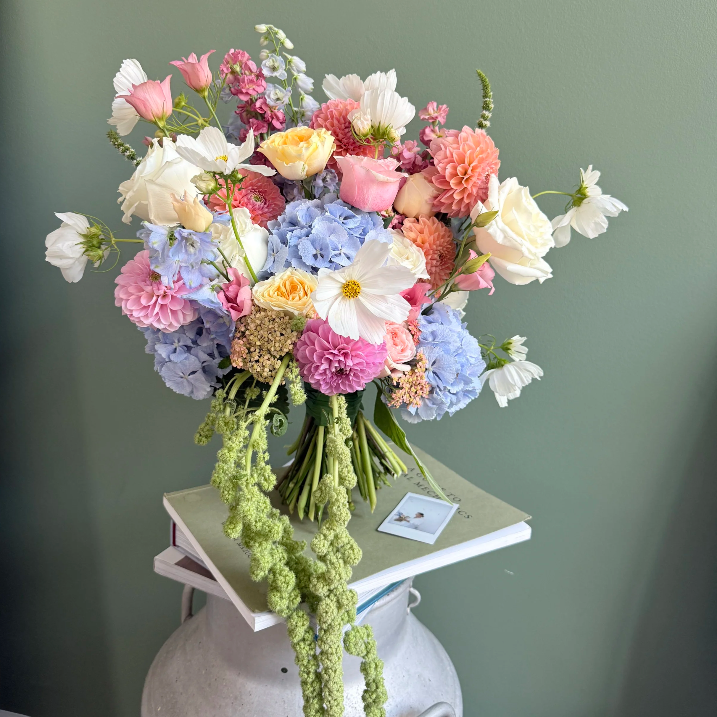 A summer bridal bouquet featuring bold colours and seasonal summer flowers such as Dahlias, Hydrangeas, Cosmos, Roses and Delphiniums. 