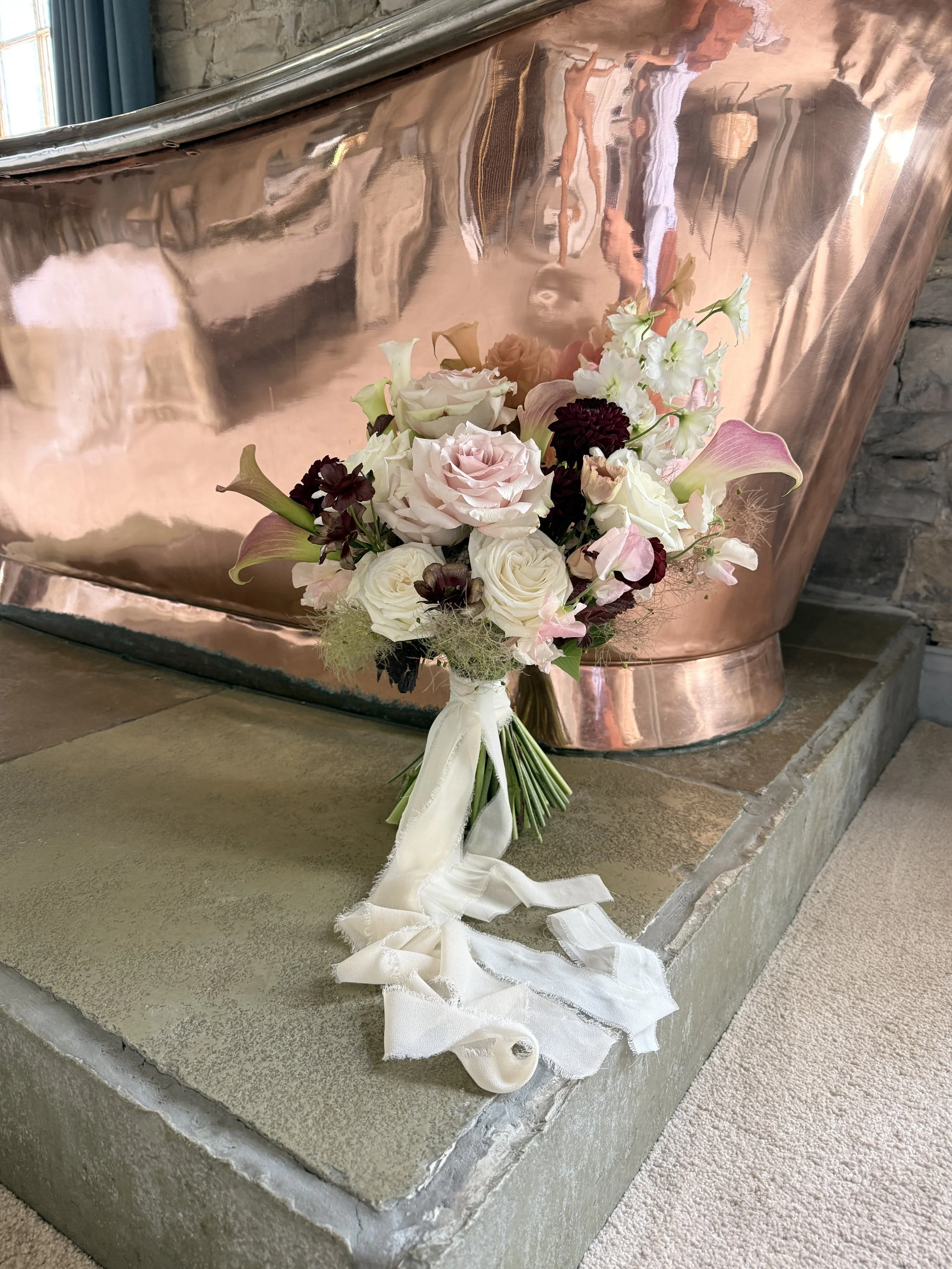 Blush and burgundy with structured and modern flower types such as Cala Lillies, Roses and deep burgundy Scabious