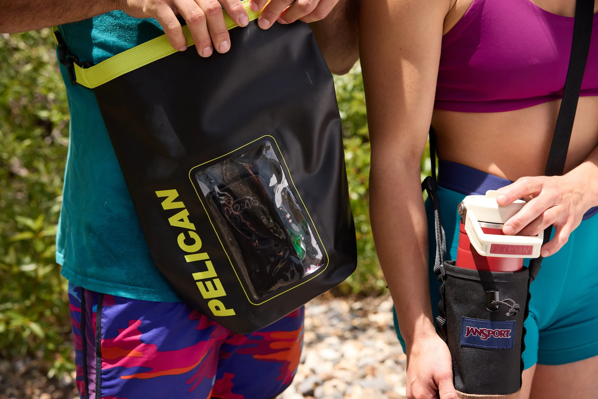 Two people in athletic clothing preparing for outdoor activity, with one holding a Petzl headlamp and the other adjusting equipment in a natural setting.