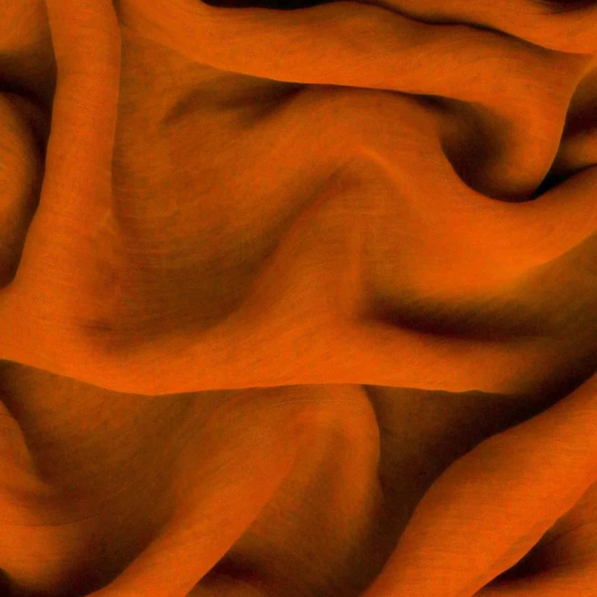 Close-up of abstract flowing orange fabric with shadows and highlights.