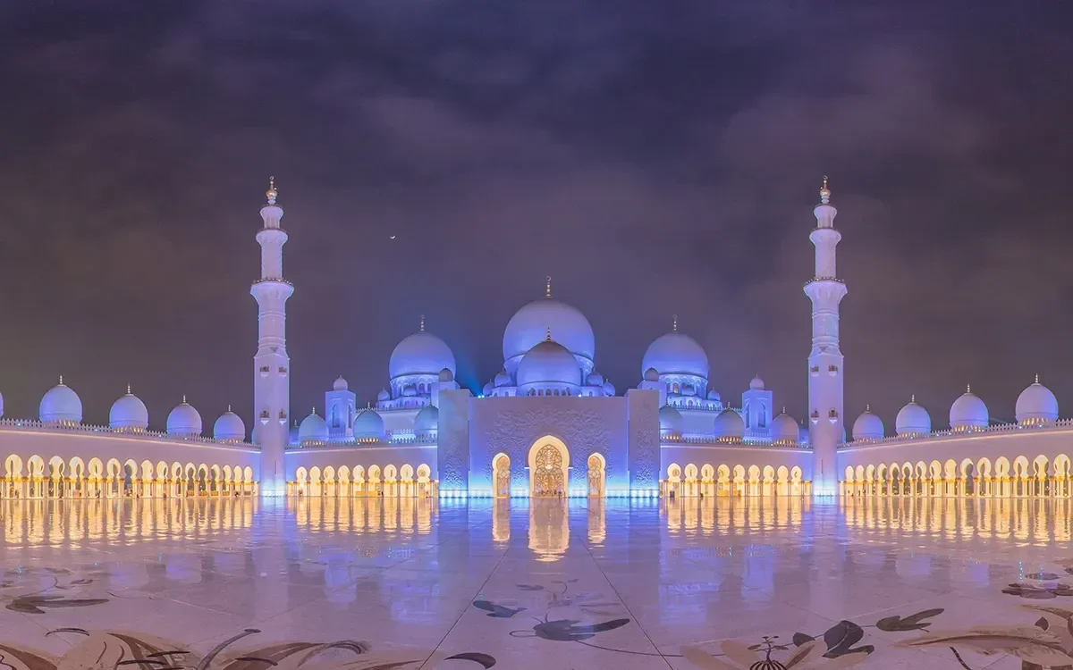 Night view of the Sheikh Zayed Grand Mosque in Abu Dhabi, representing the immersive Arabic language learning environment in ImmerseMe.