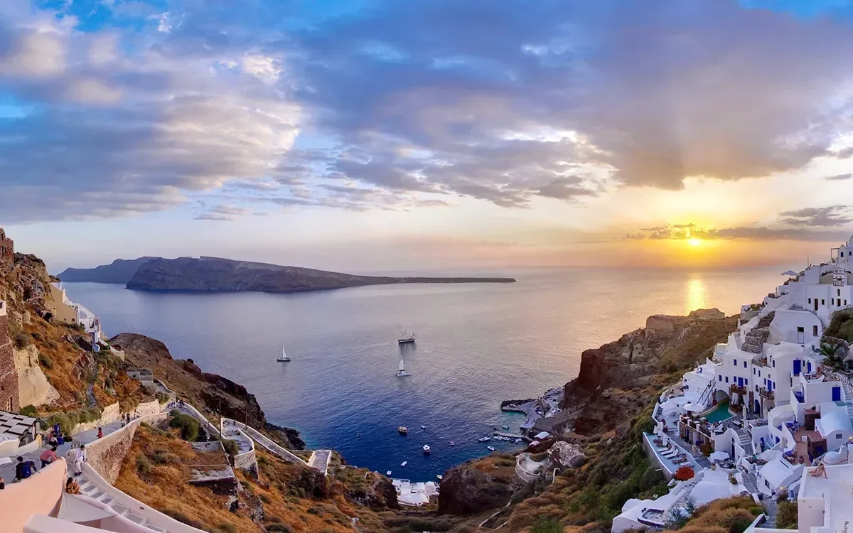 Panoramic sunset view of Oia in Santorini, Greece, representing ImmerseMe's immersive Greek language learning experiences inspired by authentic Greek culture and real-world locations.