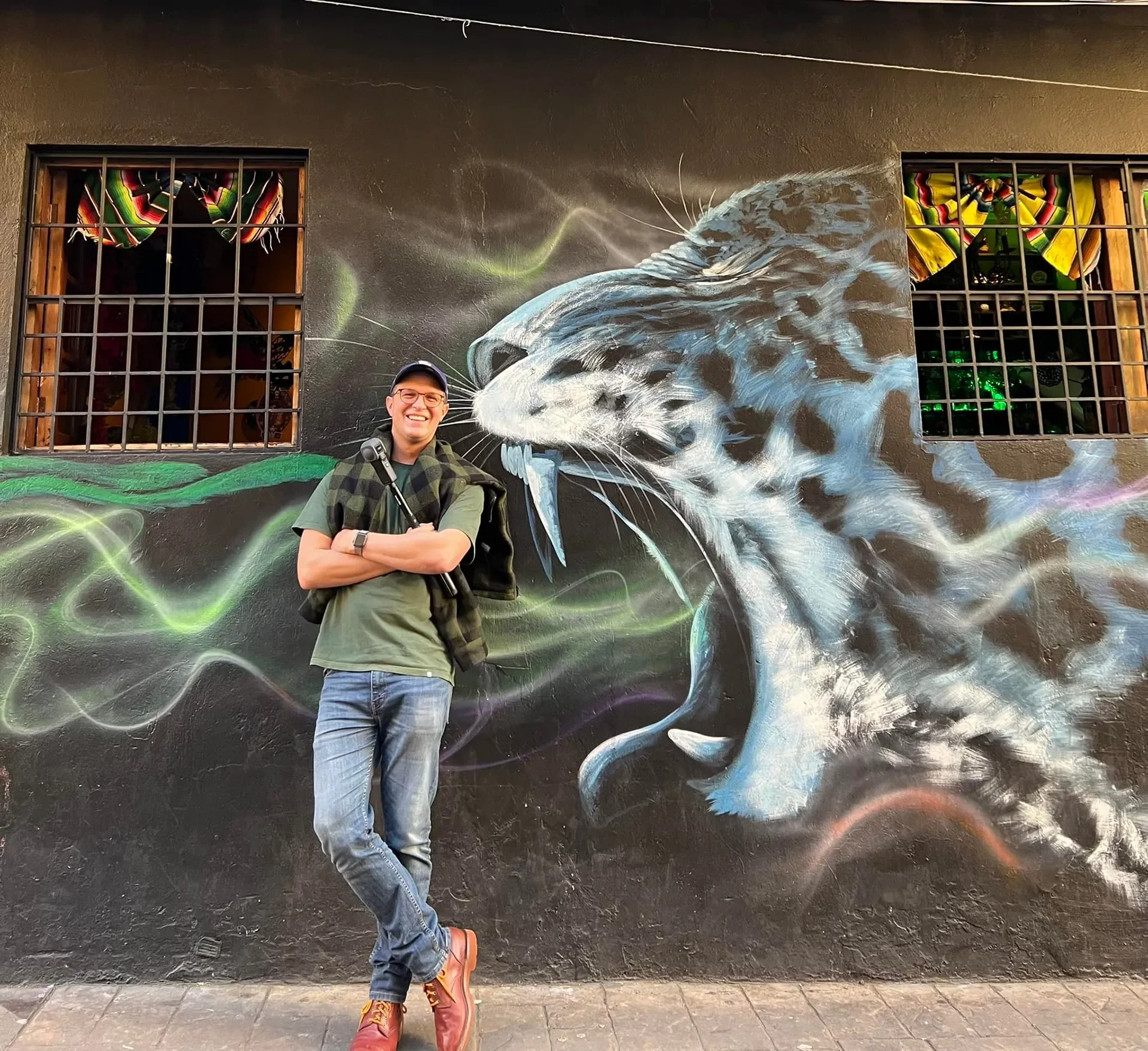 ImmerseMe founder Scott Cardwell standing beside a street-art mural.