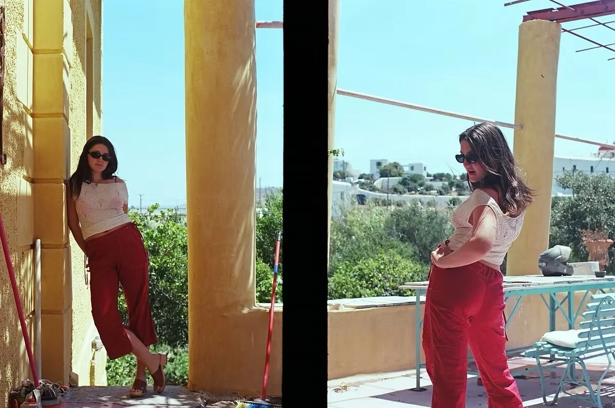 Side-by-side comparison of the same woman in two photos, wearing sunglasses, a white top, and red pants, standing outdoors against a yellow wall with a scenic view of trees and buildings in the background.