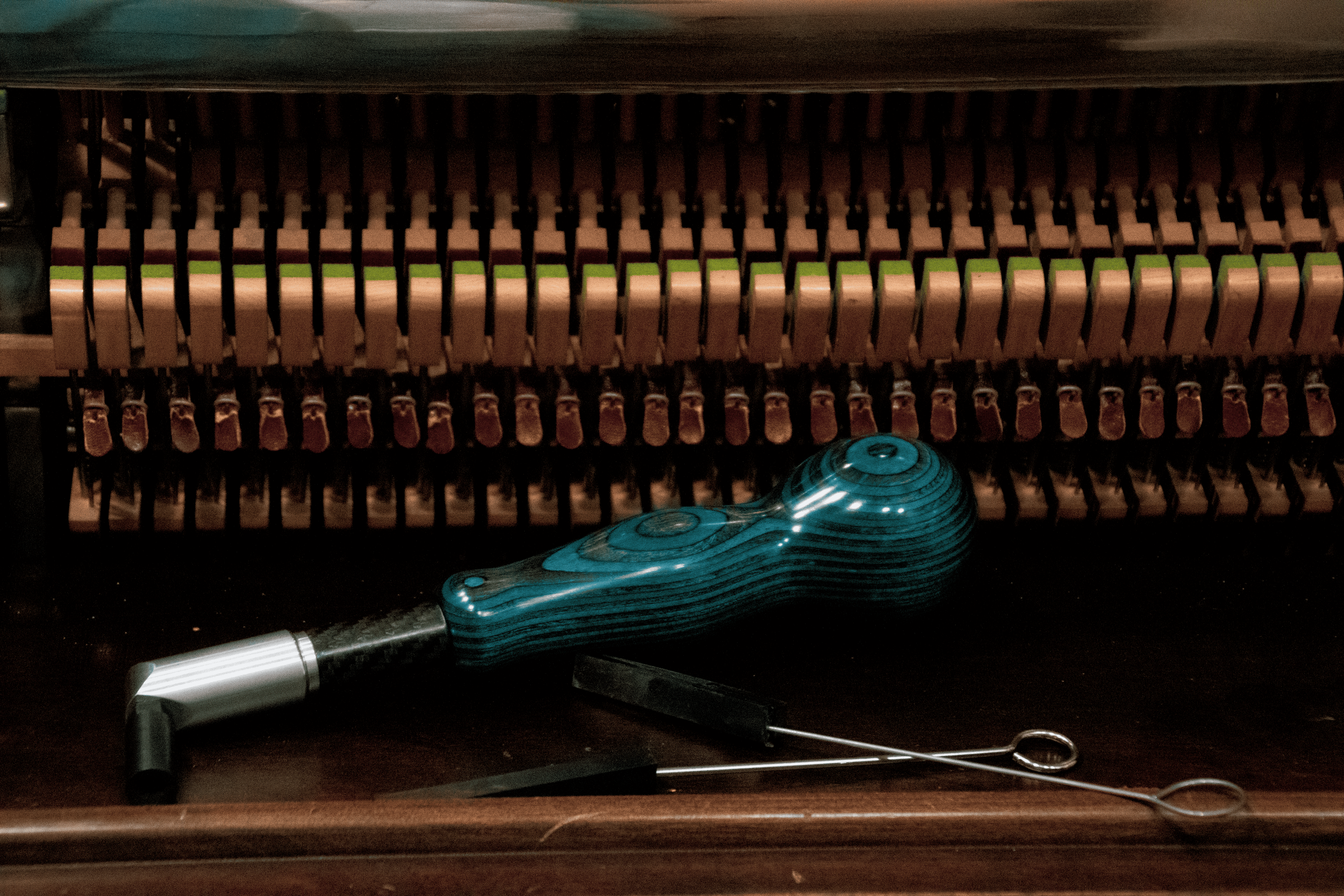 Blue tuning lever made by Charles Faulk, two rubber mutes for tuning, and the backchecks of a Schumann upright grand cabinet