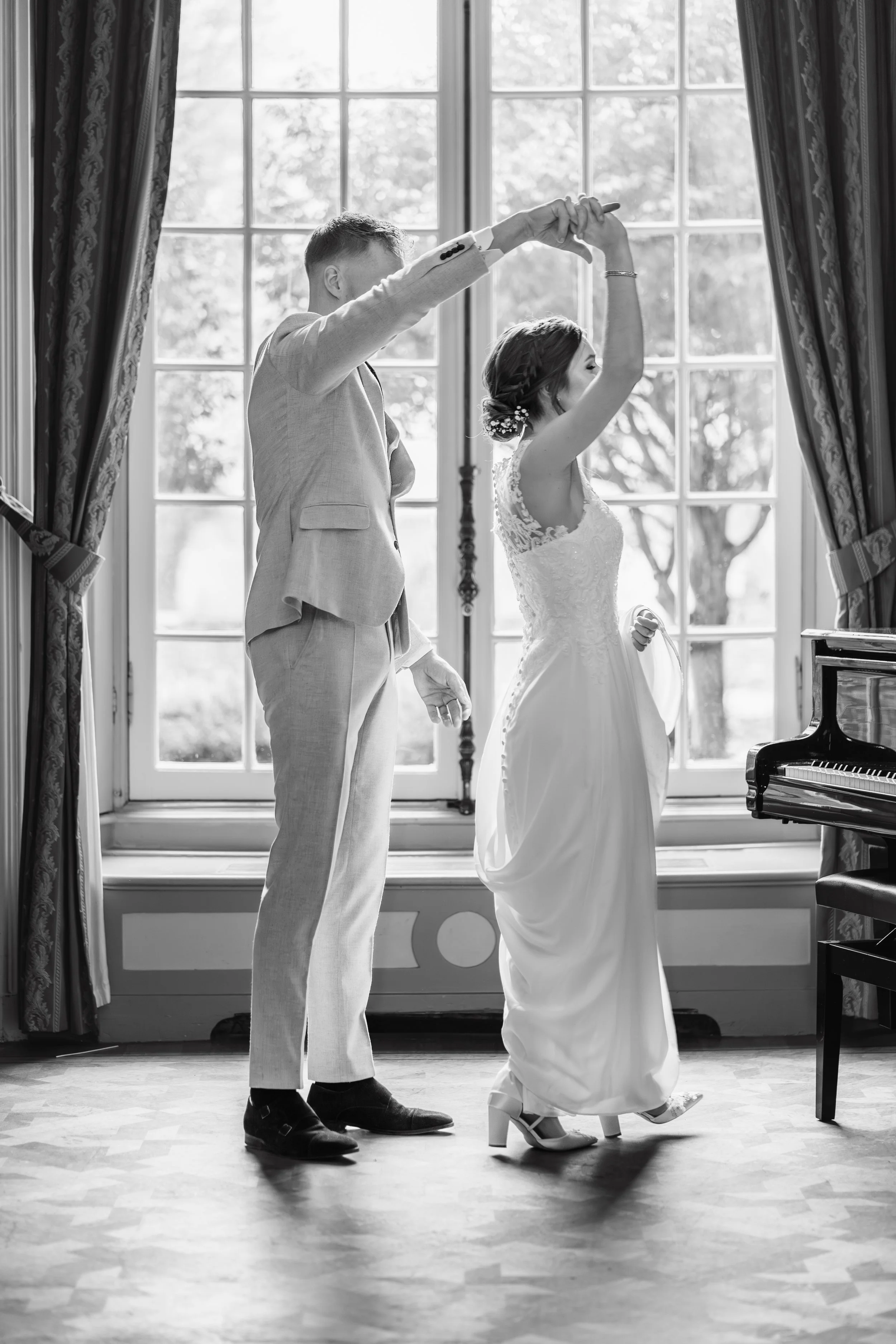 bruidspaar danst voor het raam.