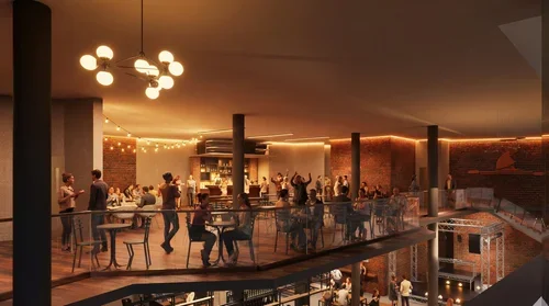 A lively indoor party or event with people mingling, dancing, and socializing in a warmly lit space with modern decor and a bar area.