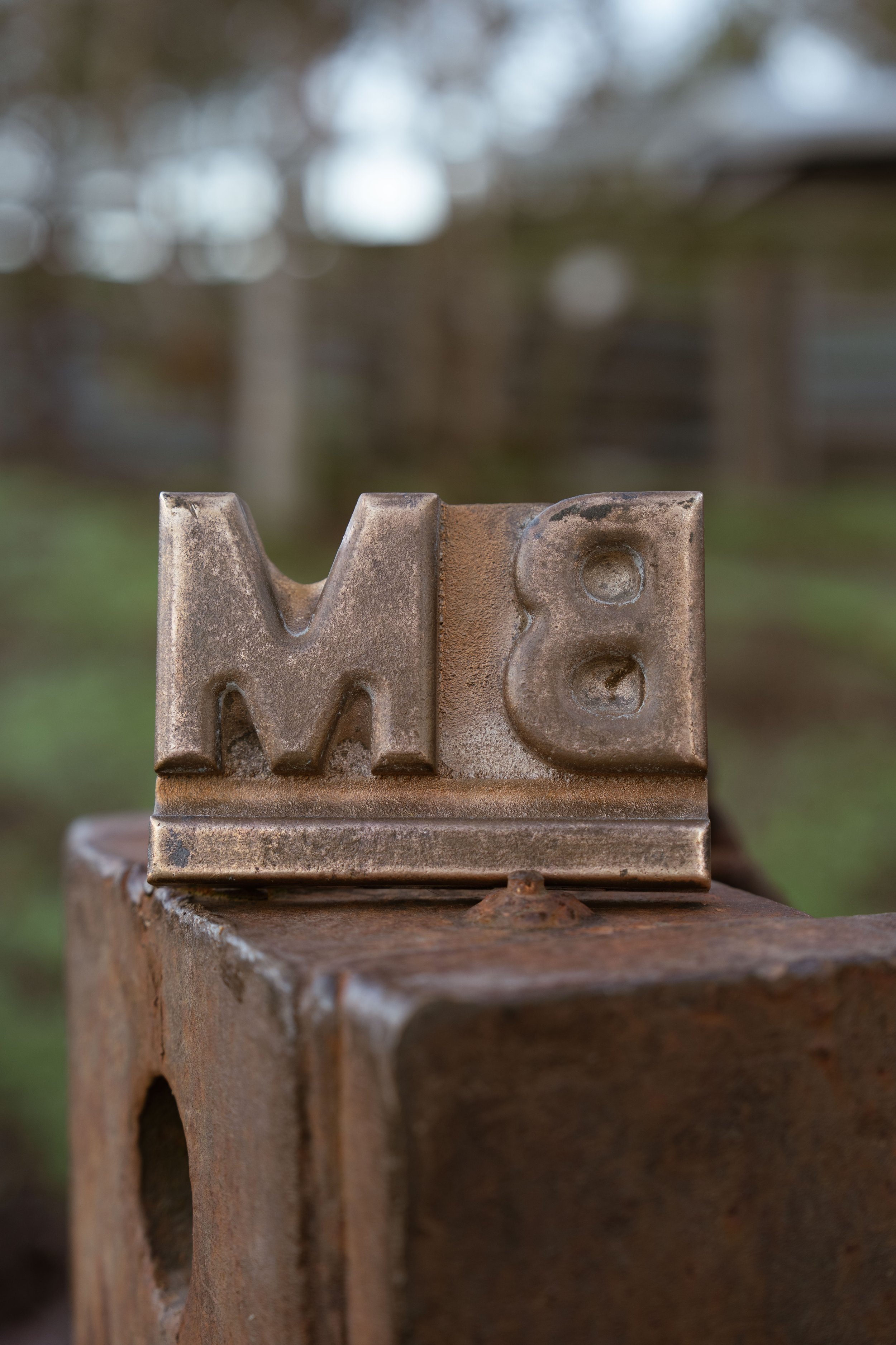The Boambee Angus BM brand in weathered steel, representing the heritage and identity of the Angus stud.