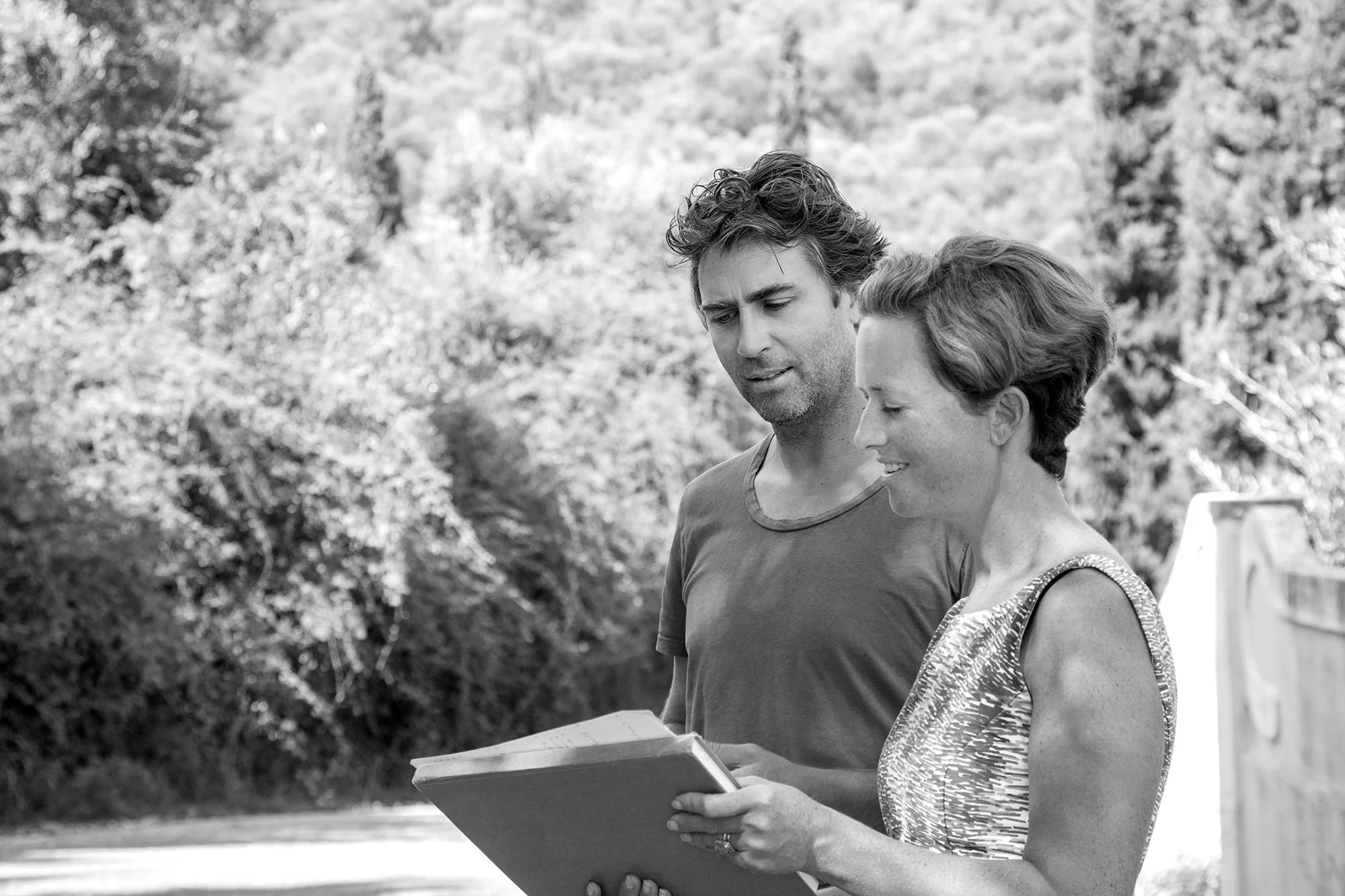 Marcus and Alithea reviewing an architectural plan outdoors.