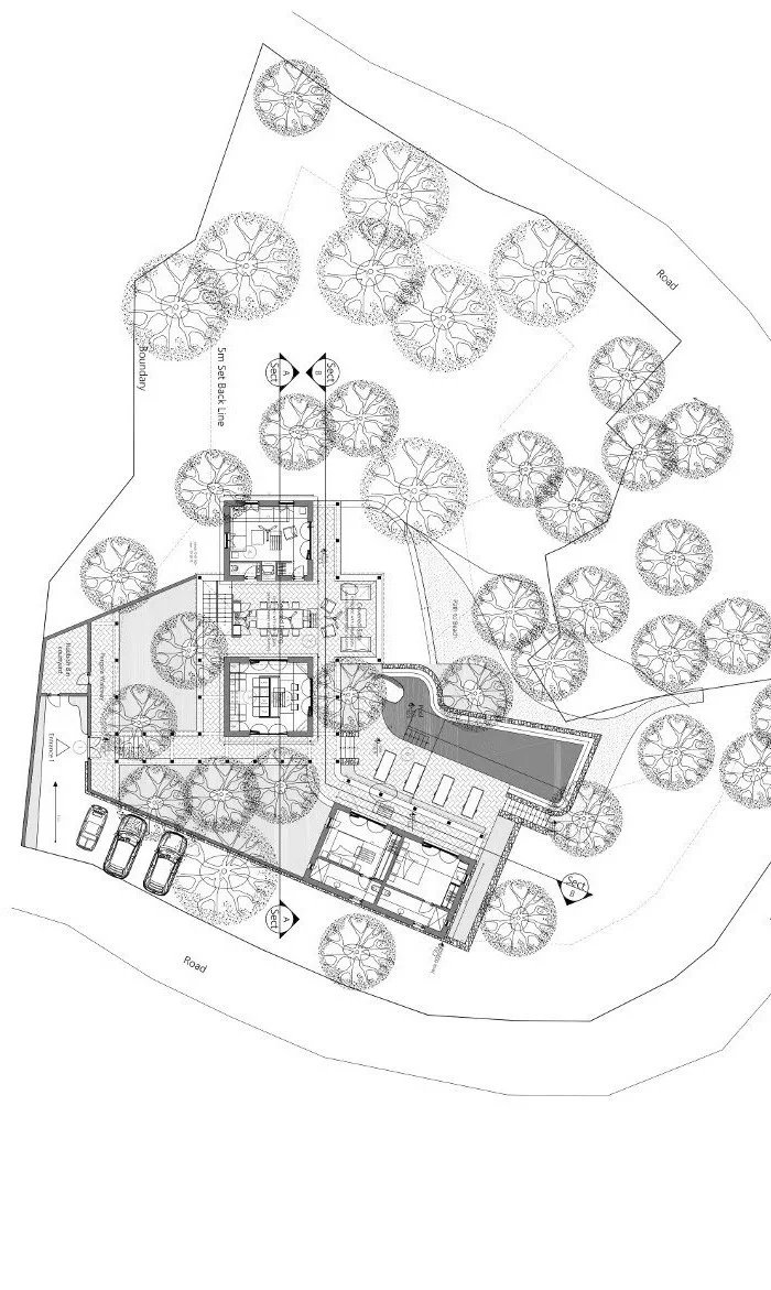 Architectural site plan of a residential property with multiple buildings, a swimming pool, landscaped areas, and parking spaces, surrounded by trees and roads.