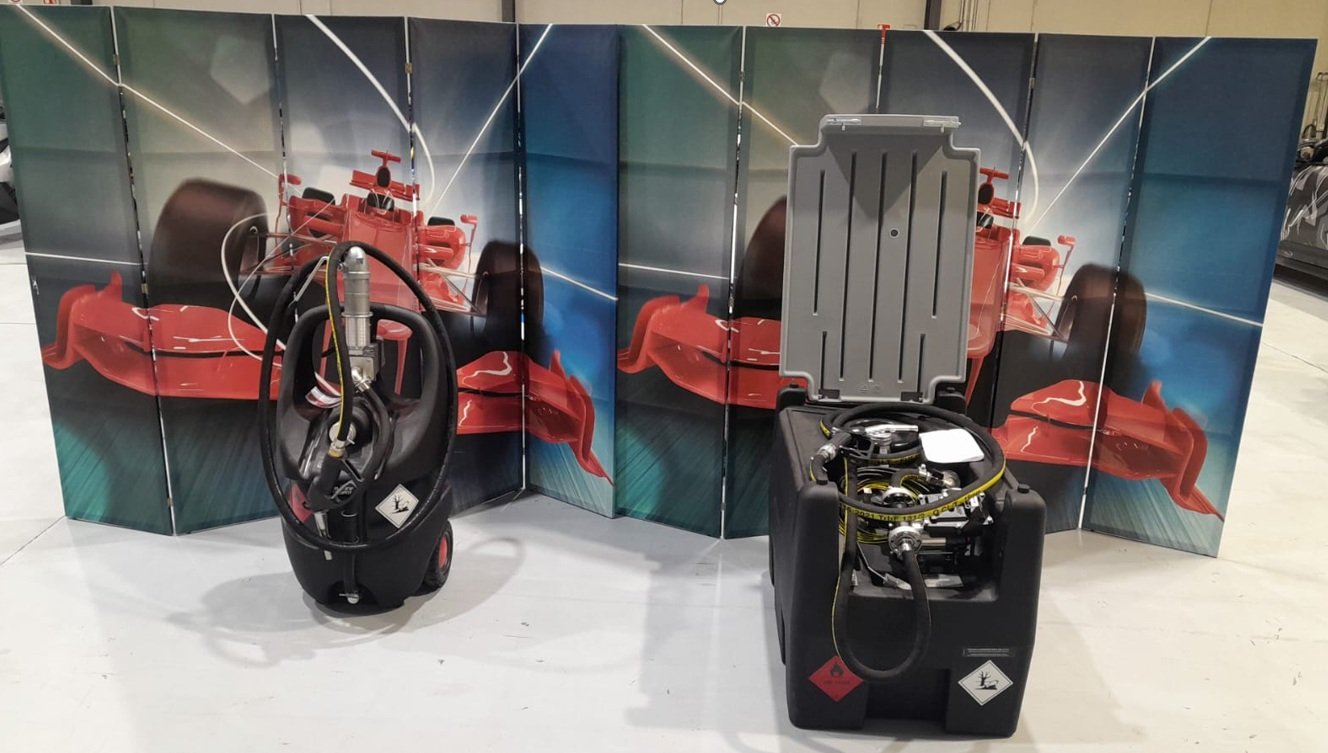 Two portable scuba diving tanks with regulators and hoses in front of a racing car-themed folding screen.