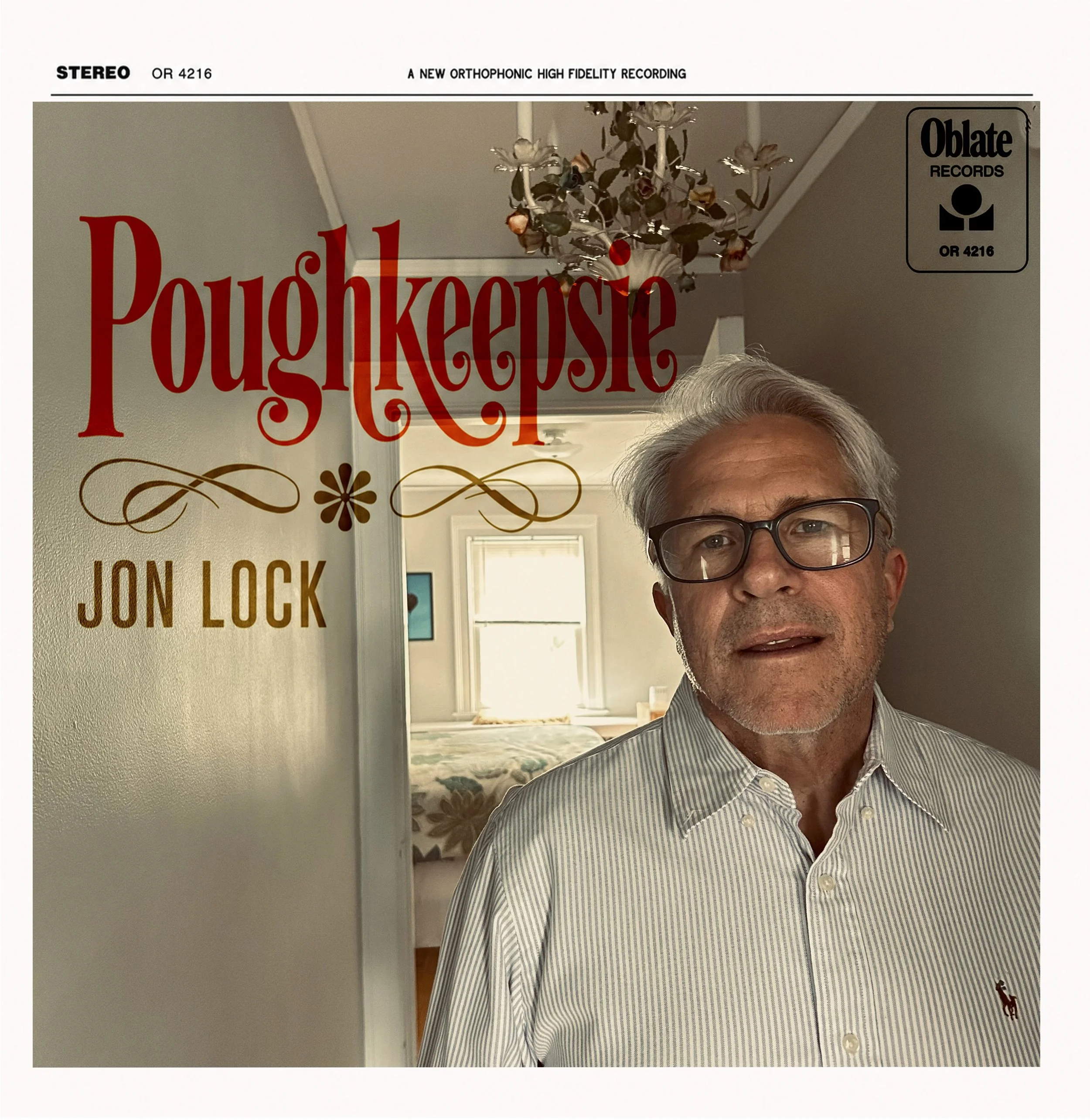 A man with gray hair and glasses taking a selfie in a room with beige walls. Behind him is a large vintage record album cover with the title 'Poughkeepsie.' The album cover features a chandelier hanging from the ceiling and a hallway with windowed doors. The man's face is partially visible in the lower right corner of the image.