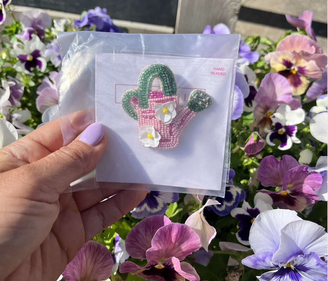 Een hand die een gepatchte haak in een plastic zak vasthoudt, met kleurrijke bloemen op de achtergrond.