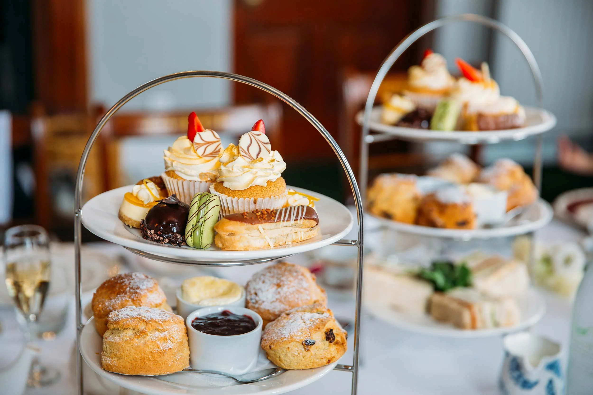 Three-tiered dessert stand with assorted pastries and cookies for a tea party or event.