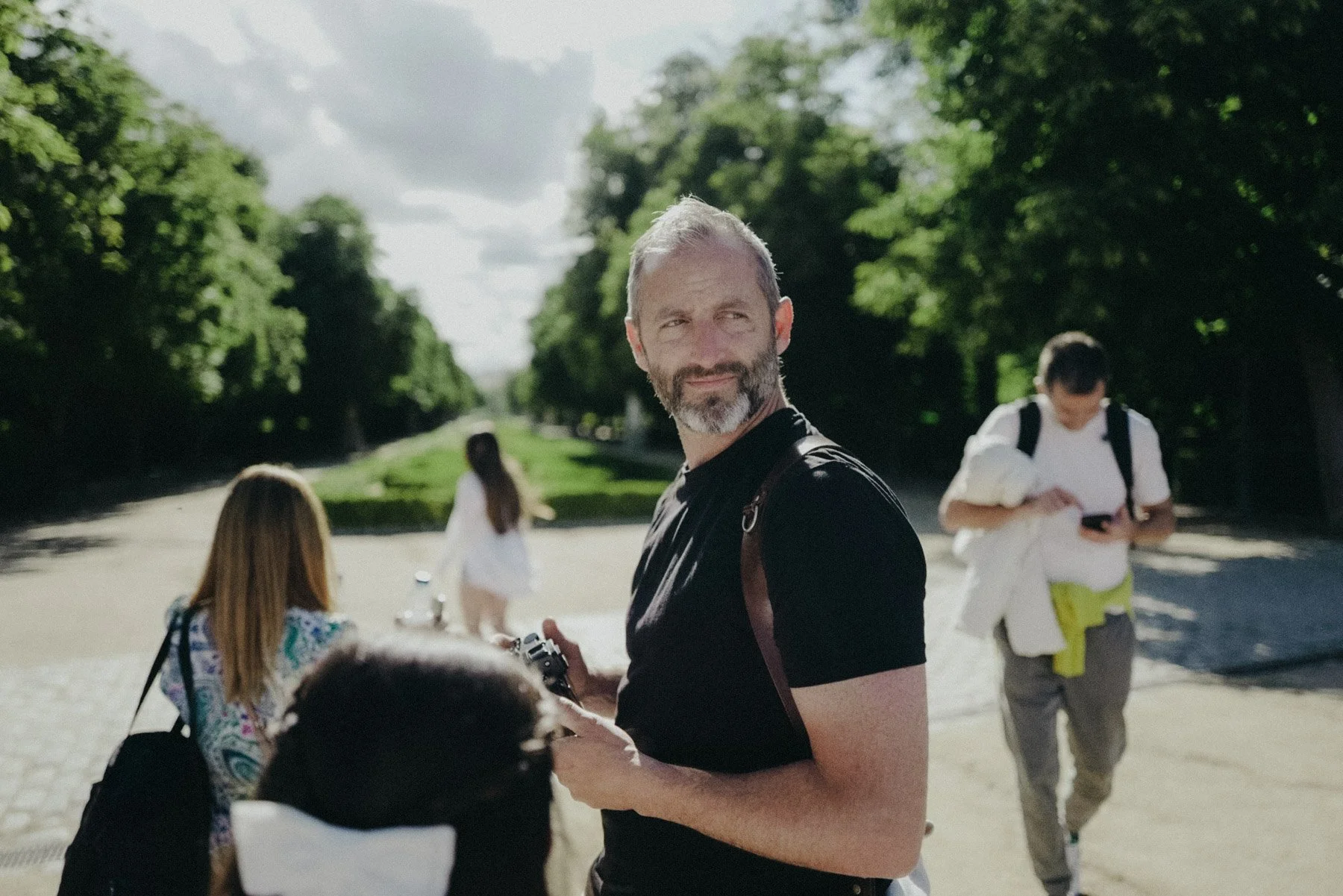 Fotógrafo de Buenafortuna con camiseta negra y cámara en mano el Parque del Retiro en Madrid