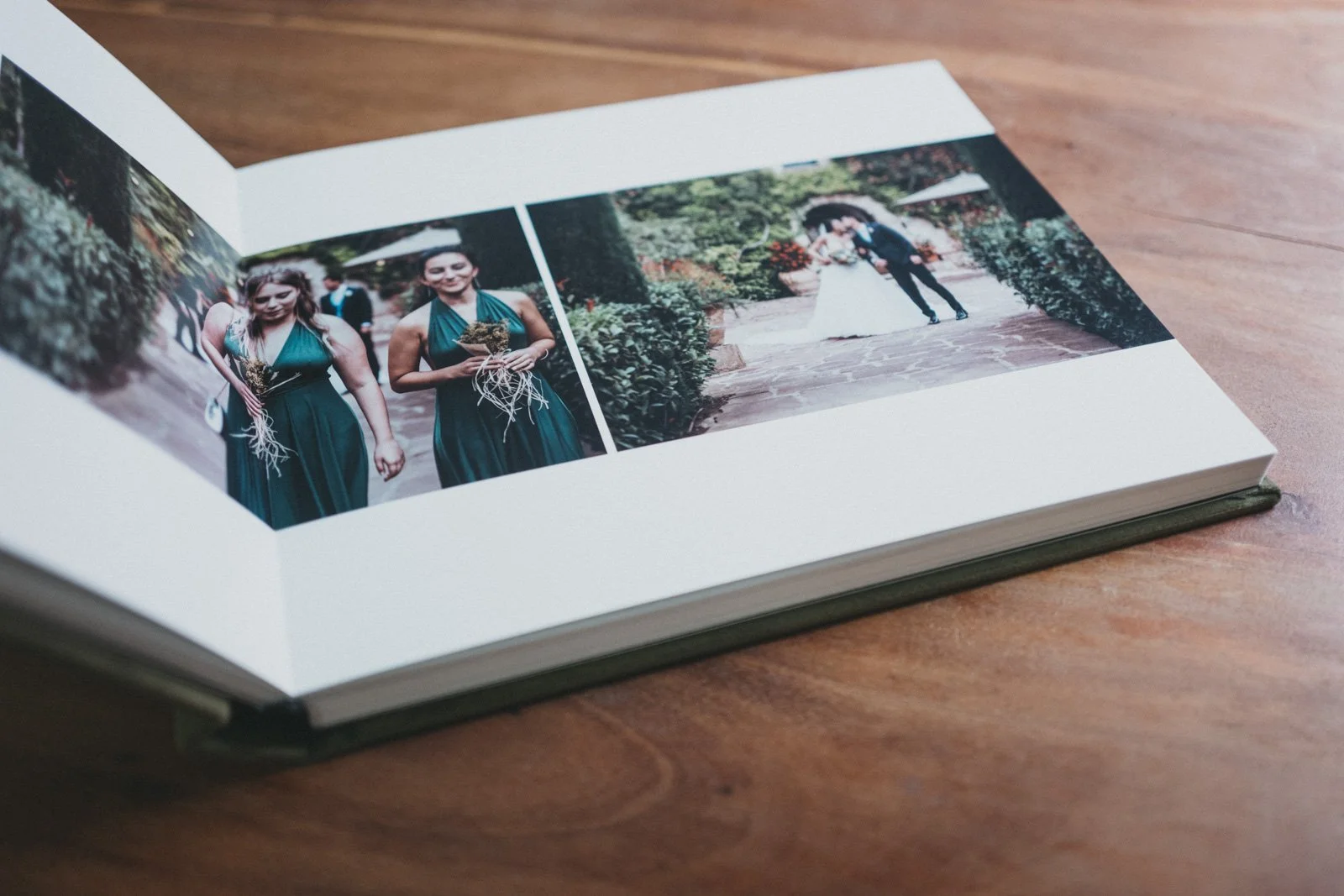 Álbum de fotos de Buenafortuna Studio con imágenes de una boda, mostrando a una mujer y en el fondo a una pareja en la ceremonia. A Buenafortuna Studio wedding album open to a spread featuring wedding photographs