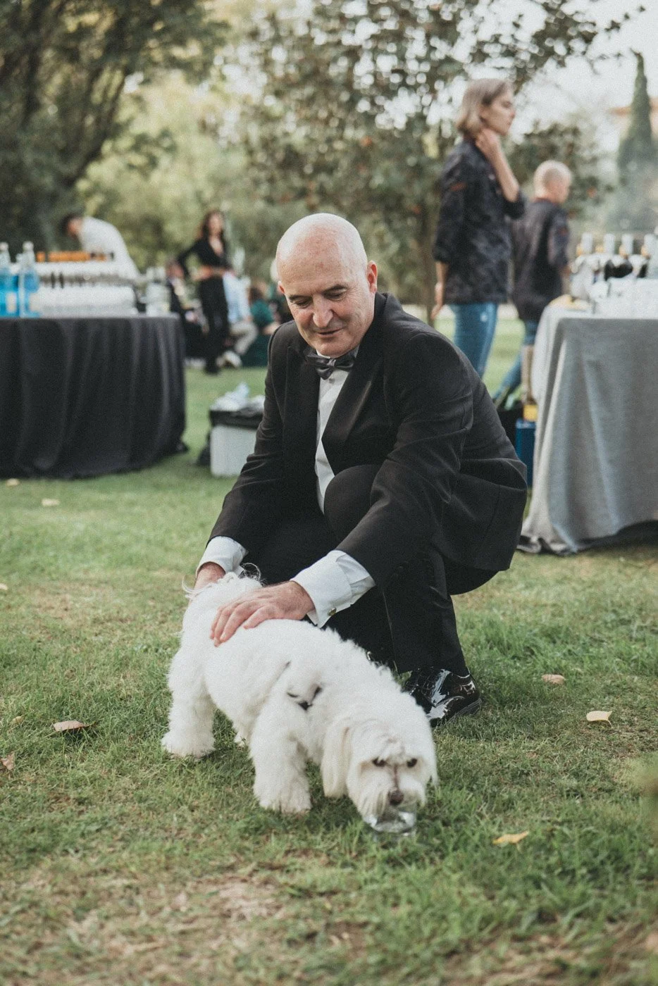 Hombre en traje y pajarita con un perro pequeño en una boda al aire libre en Cortal Gran, fotografía de boda de Buenafortuna