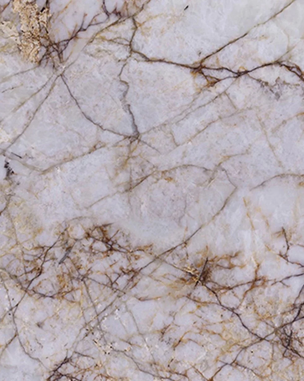 Close-up of cream-colored marble stone with brown and gold veining.